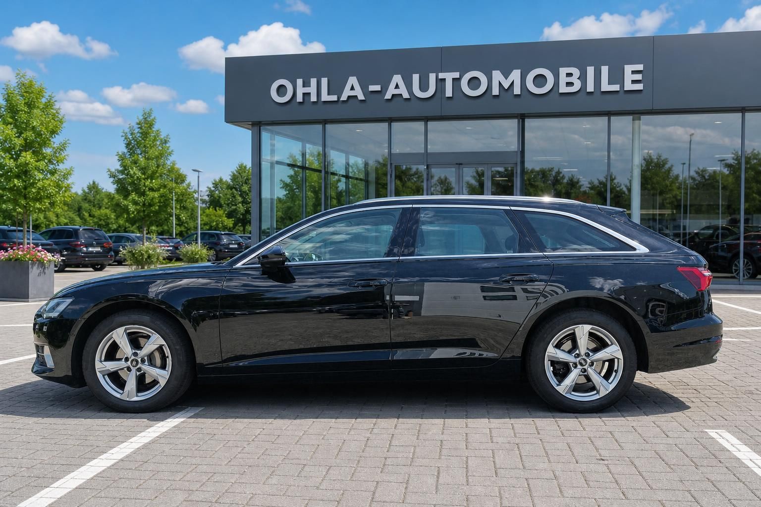 Audi A6 Avant schwarz Seitenansicht vor Autohaus OHLA
