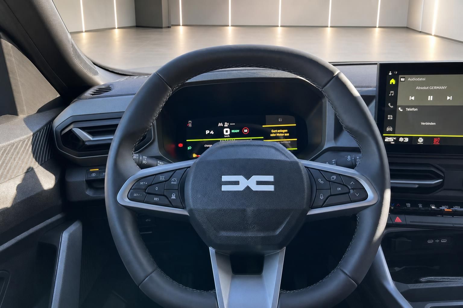 Detailansicht Fahrzeug Lenkrad mit Multifunktionstasten und digitalem Cockpit Display dahinter