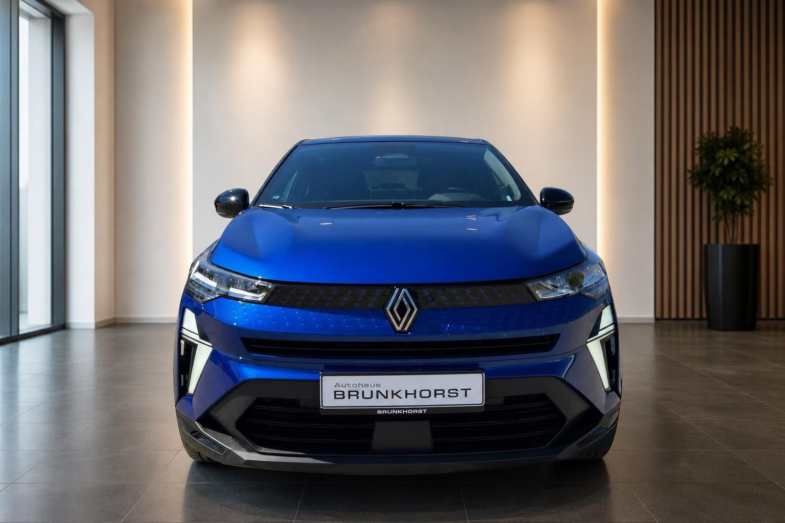 Blauer Renault Fahrzeug Frontansicht im modernen Autohaus Showroom mit eleganter Beleuchtung