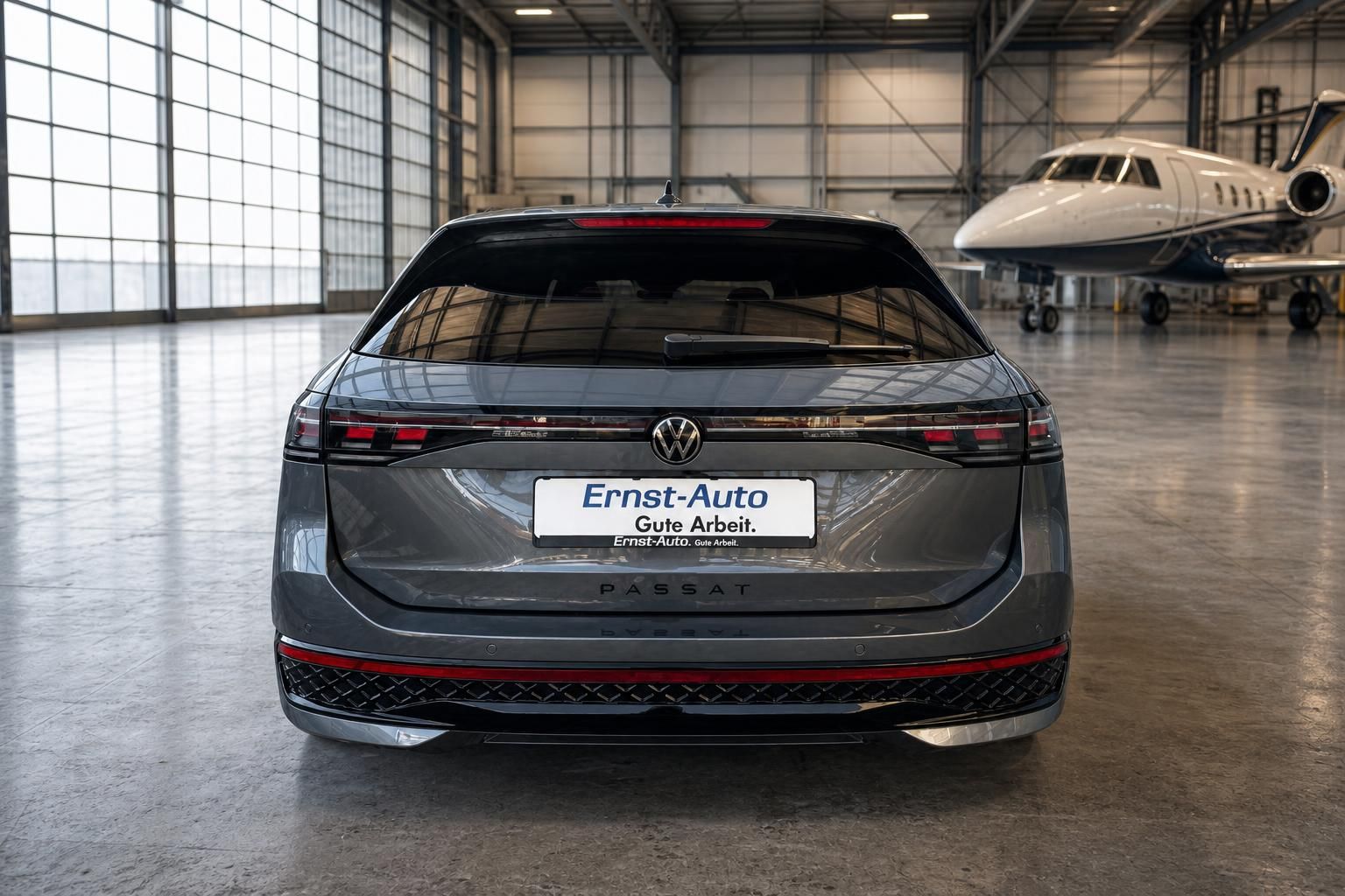 VW Passat Kombi grau - Heckansicht mit PASSAT Schriftzug und Händlerkennzeichen in Flugzeughalle