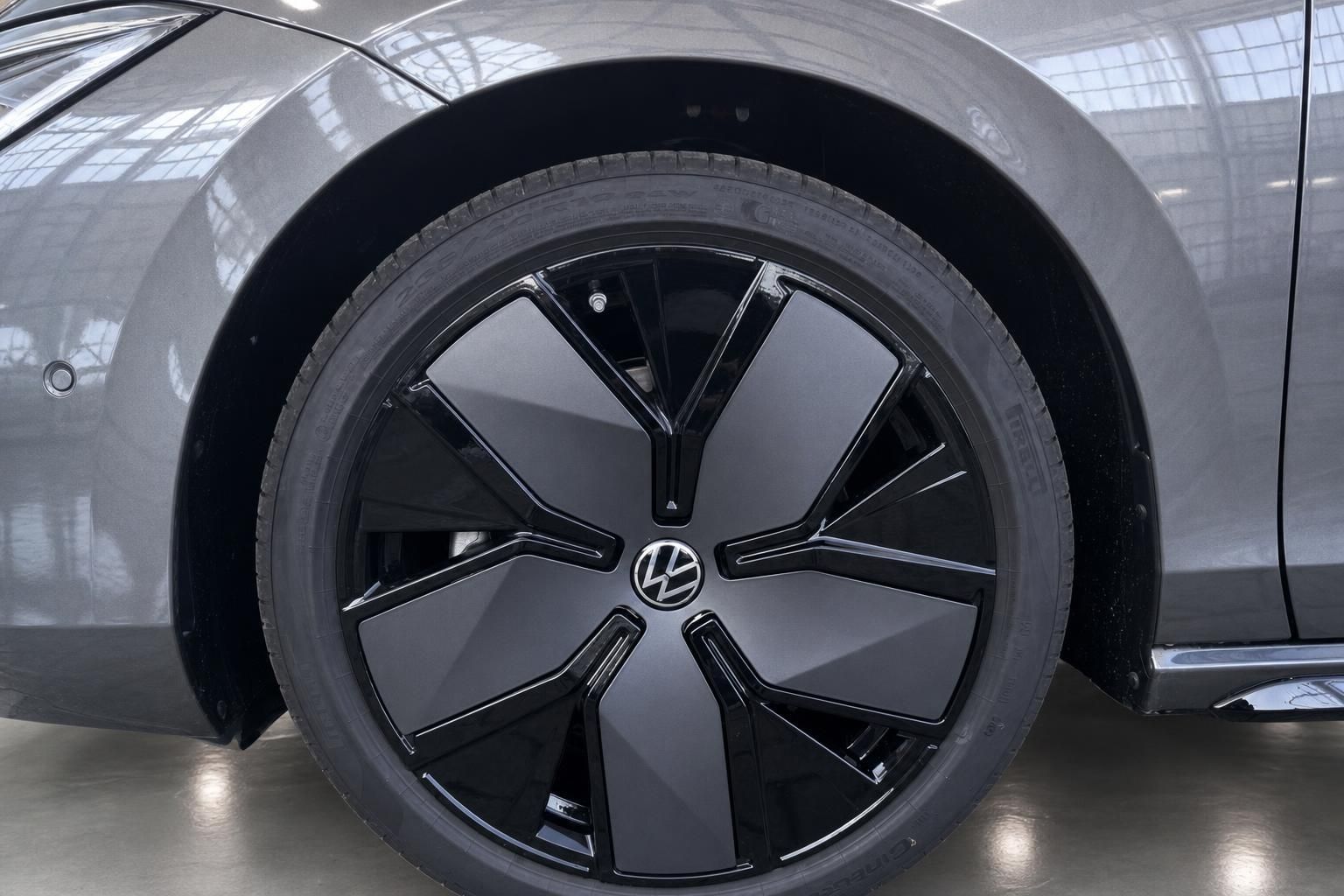 Volkswagen Felge mit schwarzem Design und VW-Logo in grauem Fahrzeug - Detailaufnahme Rad