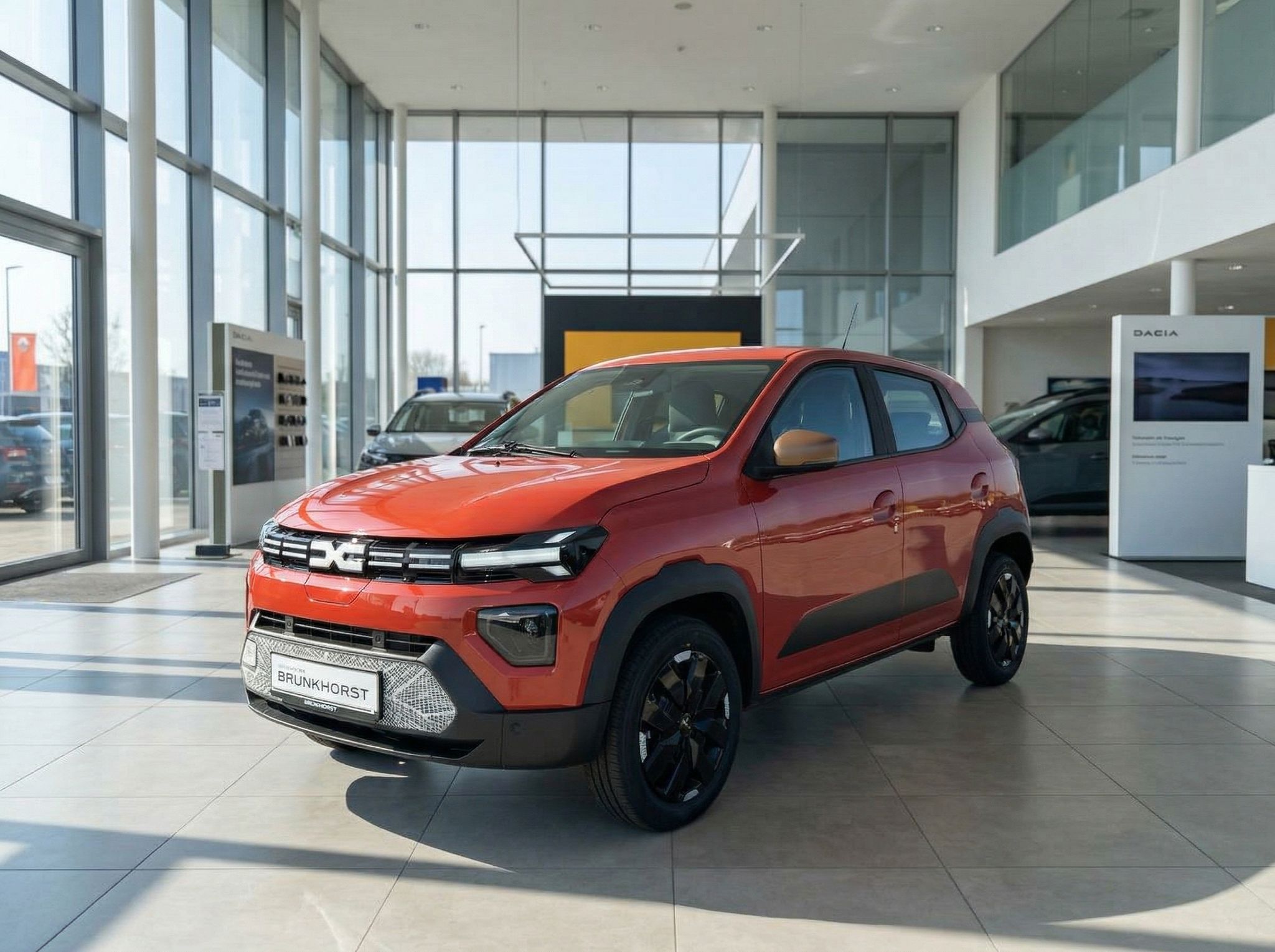 Dacia Spring Elektroauto in Orange im Autohaus Showroom - Kompakt-SUV von der Seite