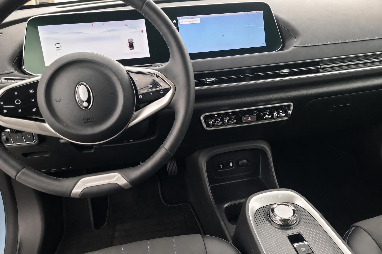 Fahrzeug Innenraum mit Lenkrad, digitalem Cockpit und Infotainment-Display in schwarzem Design