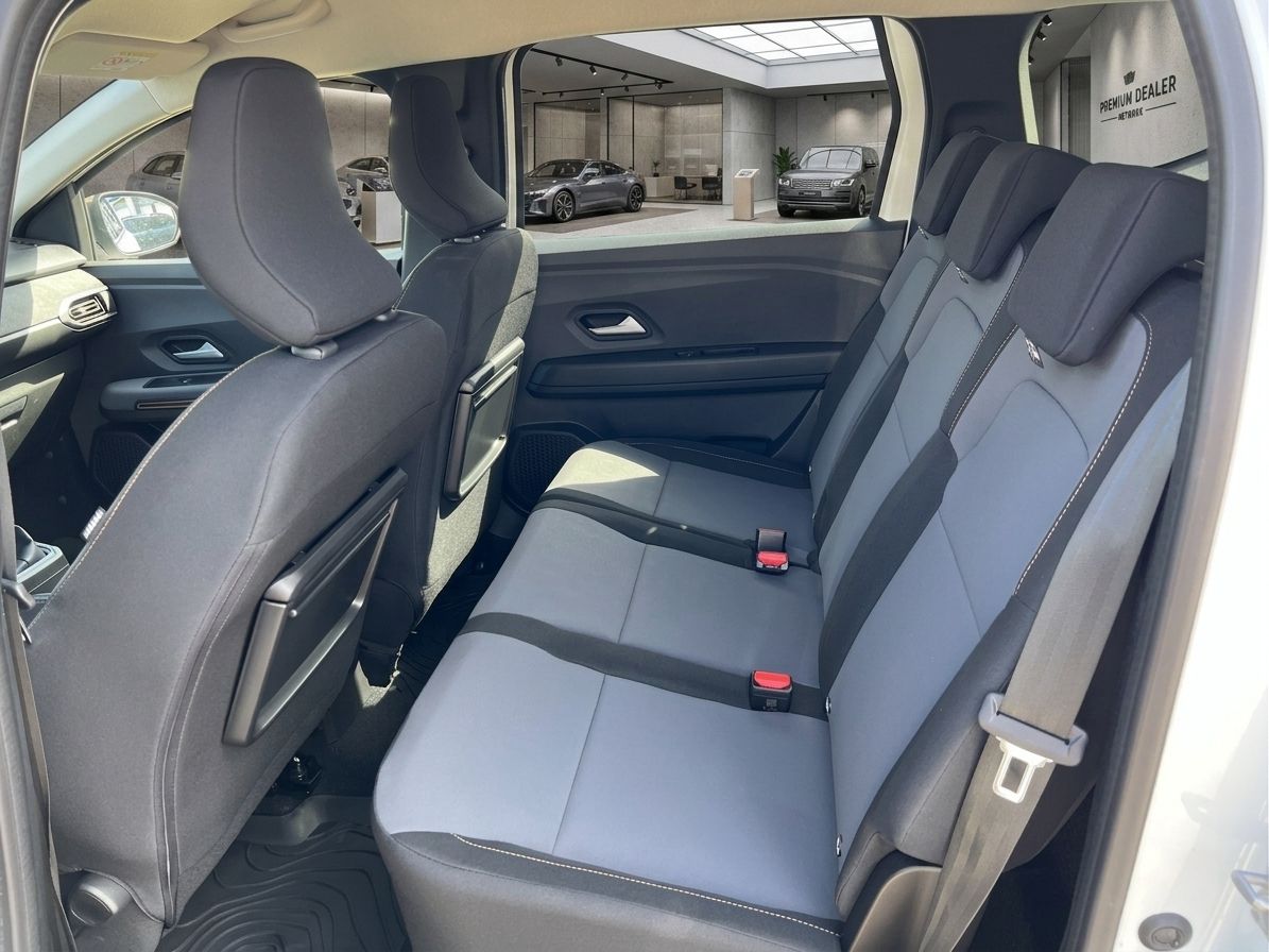 Dacia Rücksitzbank mit grauen Sitzen und Sicherheitsgurten im Autohaus-Showroom