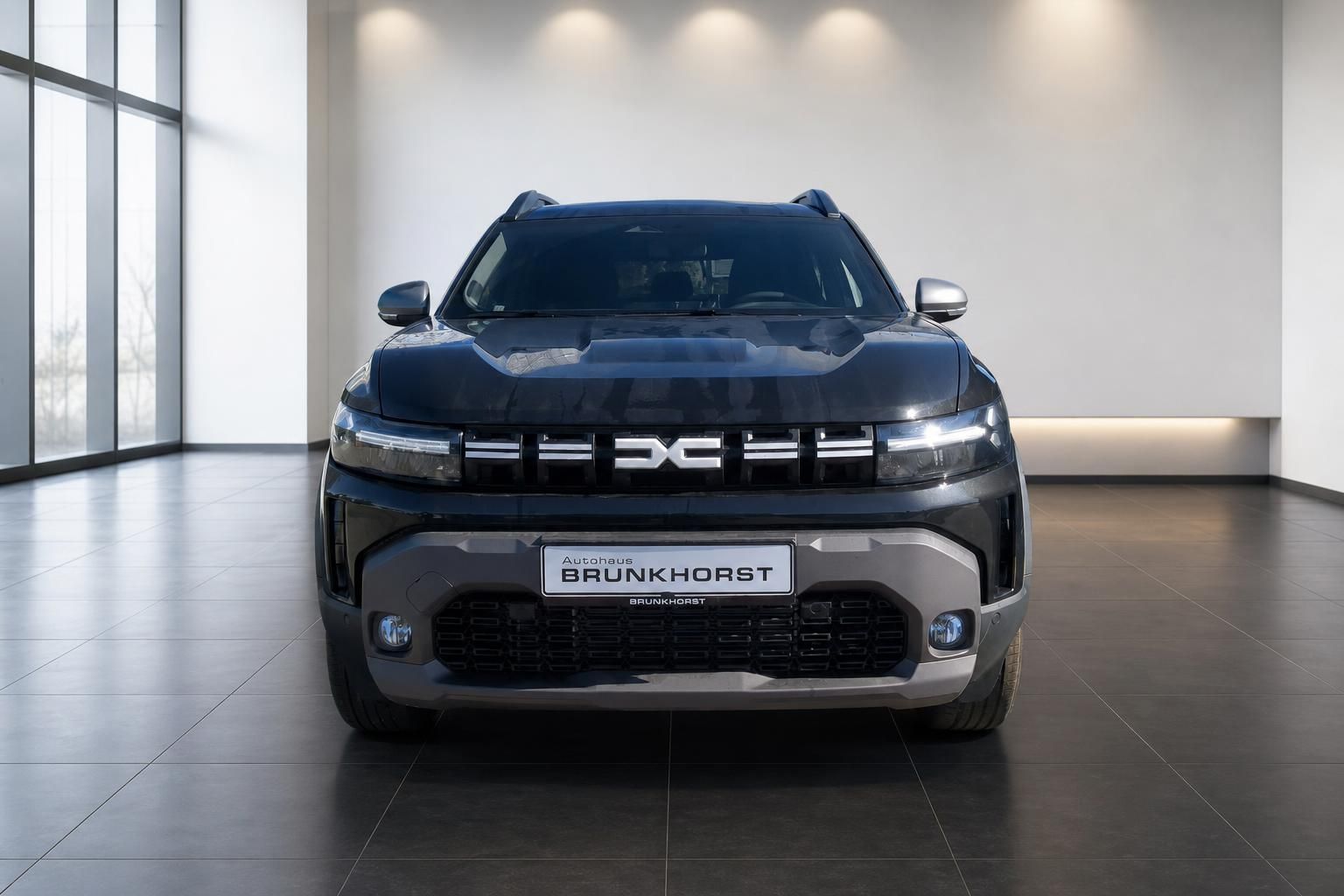 Dacia Duster SUV Frontansicht dunkelblau im hellen Autohaus-Showroom mit Glasfront