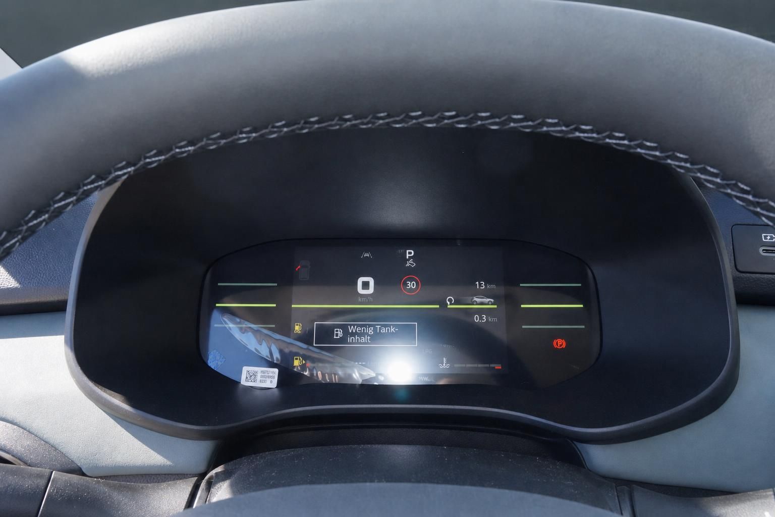 Digitales Kombiinstrument im Fahrzeug-Innenraum mit Tachoanzeige und Warnanzeigen