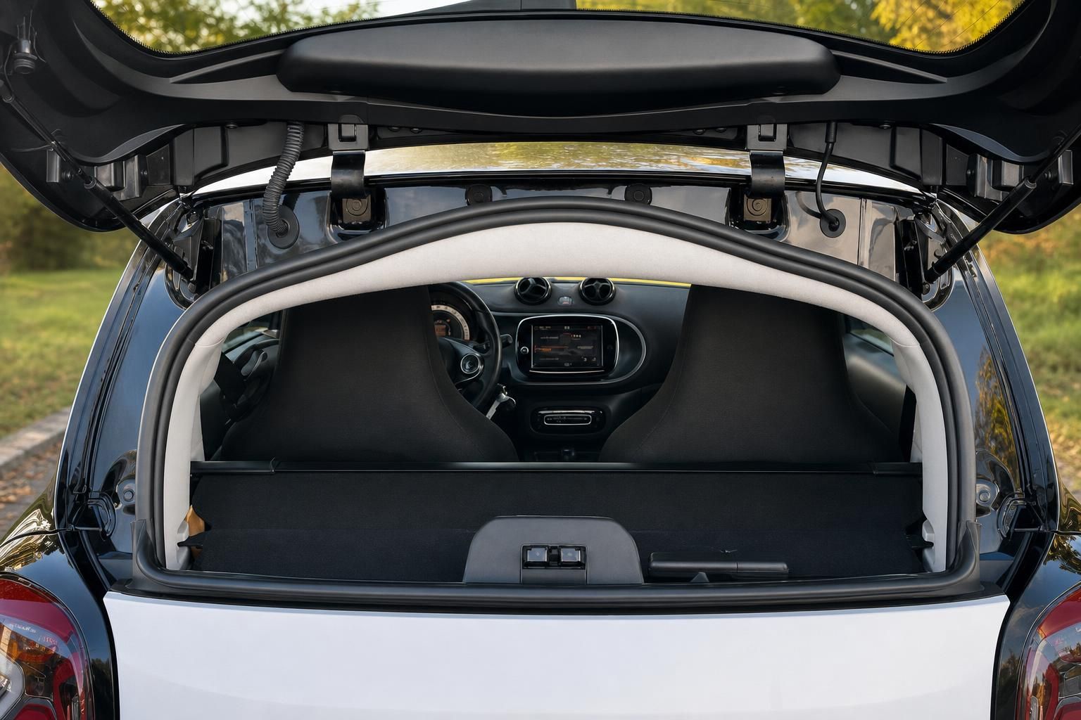 Geöffneter Kofferraum mit Blick auf Innenraum und Fahrzeug-Cockpit