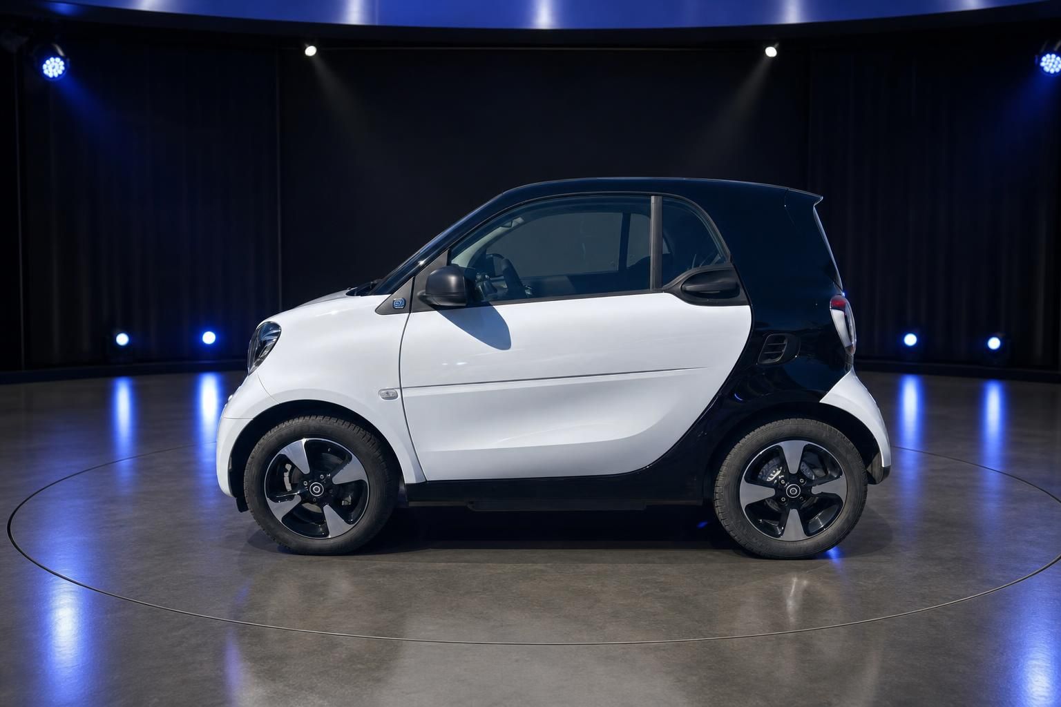 Smart Elektroauto weiß-schwarz Seitenansicht links in modernem Showroom