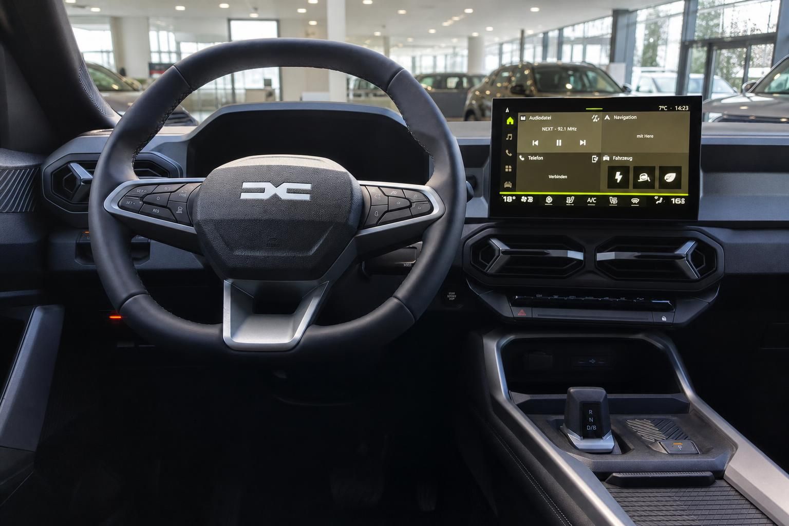 Fahrzeug Innenraum mit schwarzem Lenkrad, Touchscreen Display und modernem Cockpit