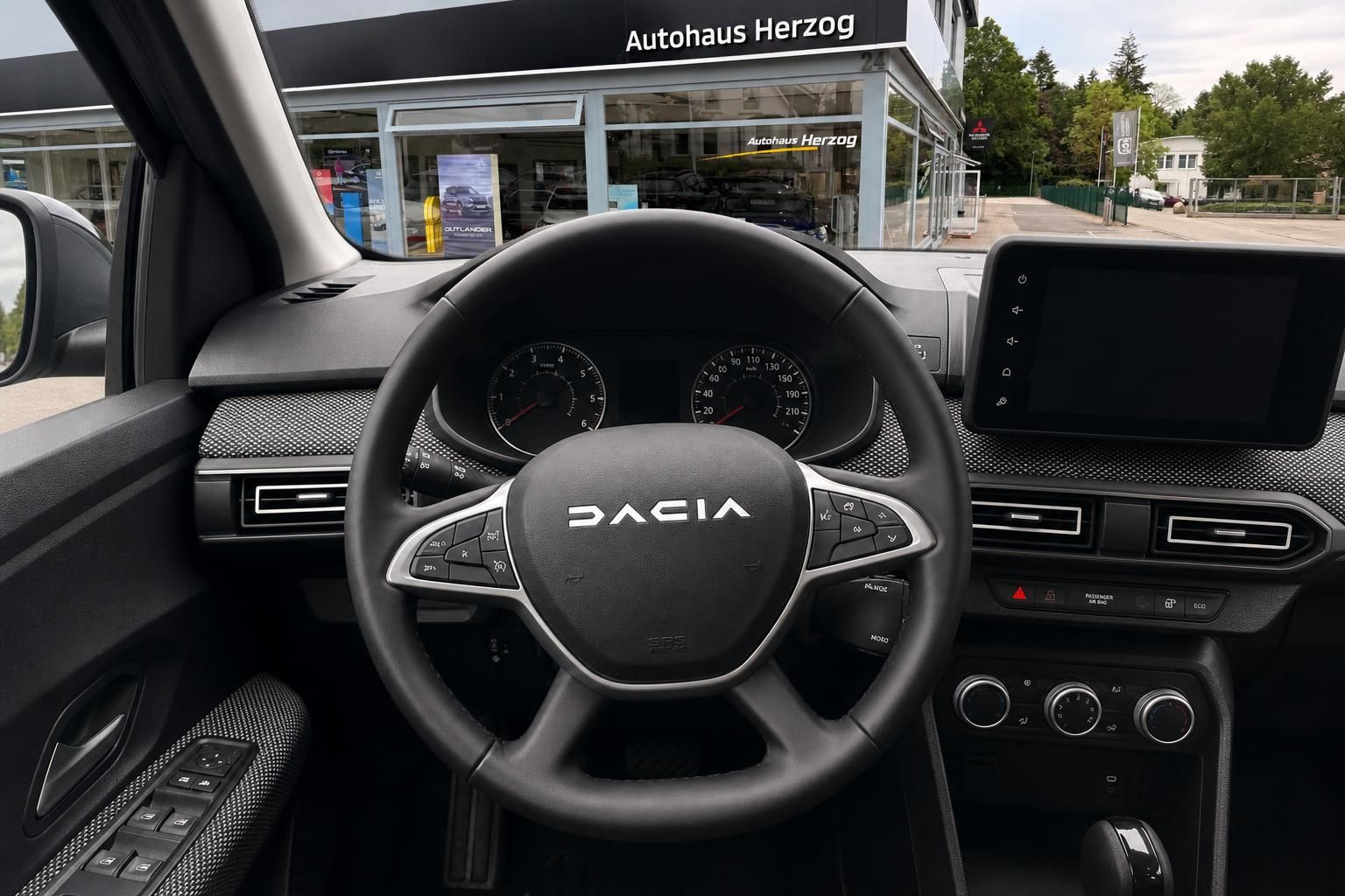 Dacia Fahrzeug Cockpit mit Lenkrad, Tacho und Infotainment Display im Innenraum