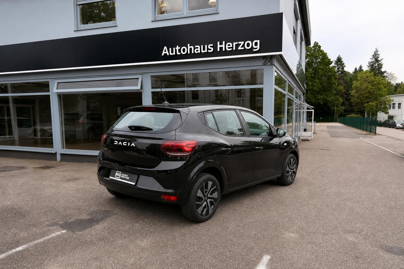 Dacia Sandero in Schwarz - Heck-Seitenansicht mit sportlichen Leichtmetallfelgen vor Autohaus Herzog