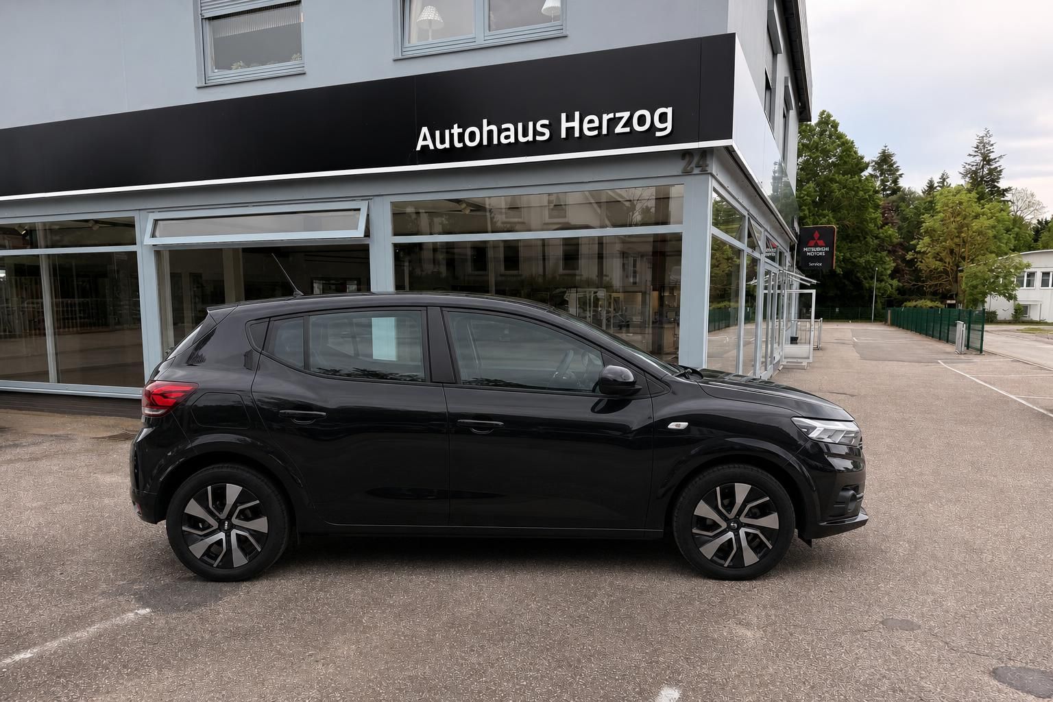 Schwarzer Dacia SUV Seitenansicht vor Autohaus Herzog