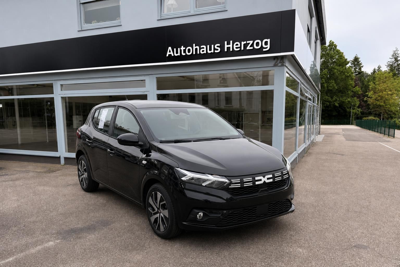 Schwarzer Dacia SUV Frontansicht vor Autohaus Herzog