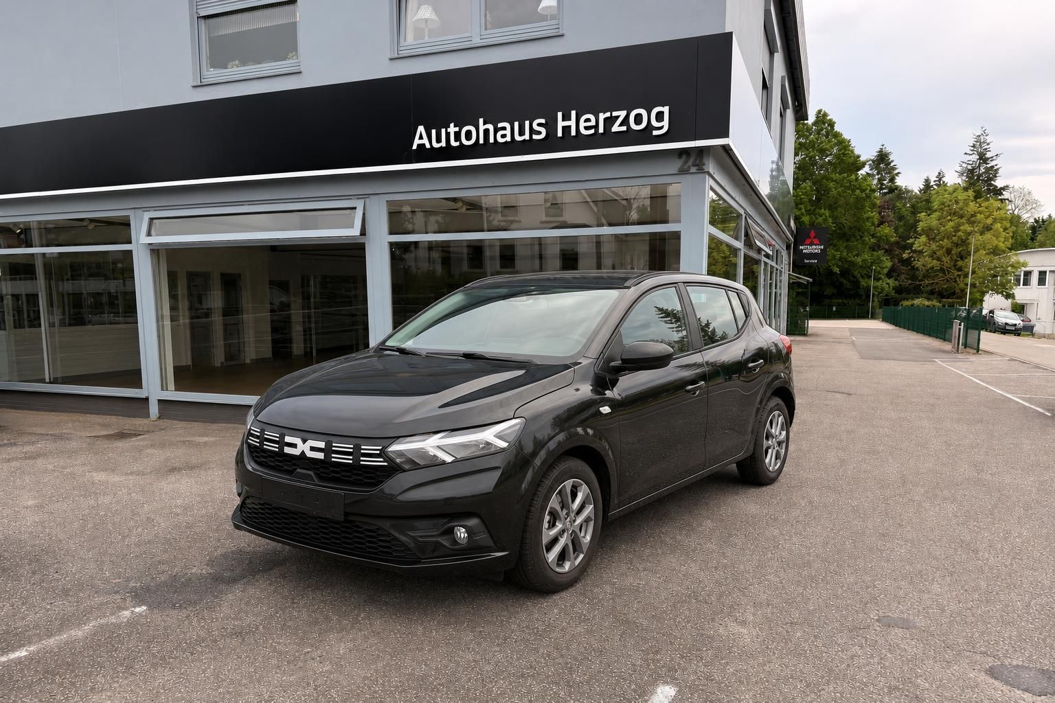 Schwarzer Dacia SUV Dreiviertel-Frontansicht vor Autohaus Herzog