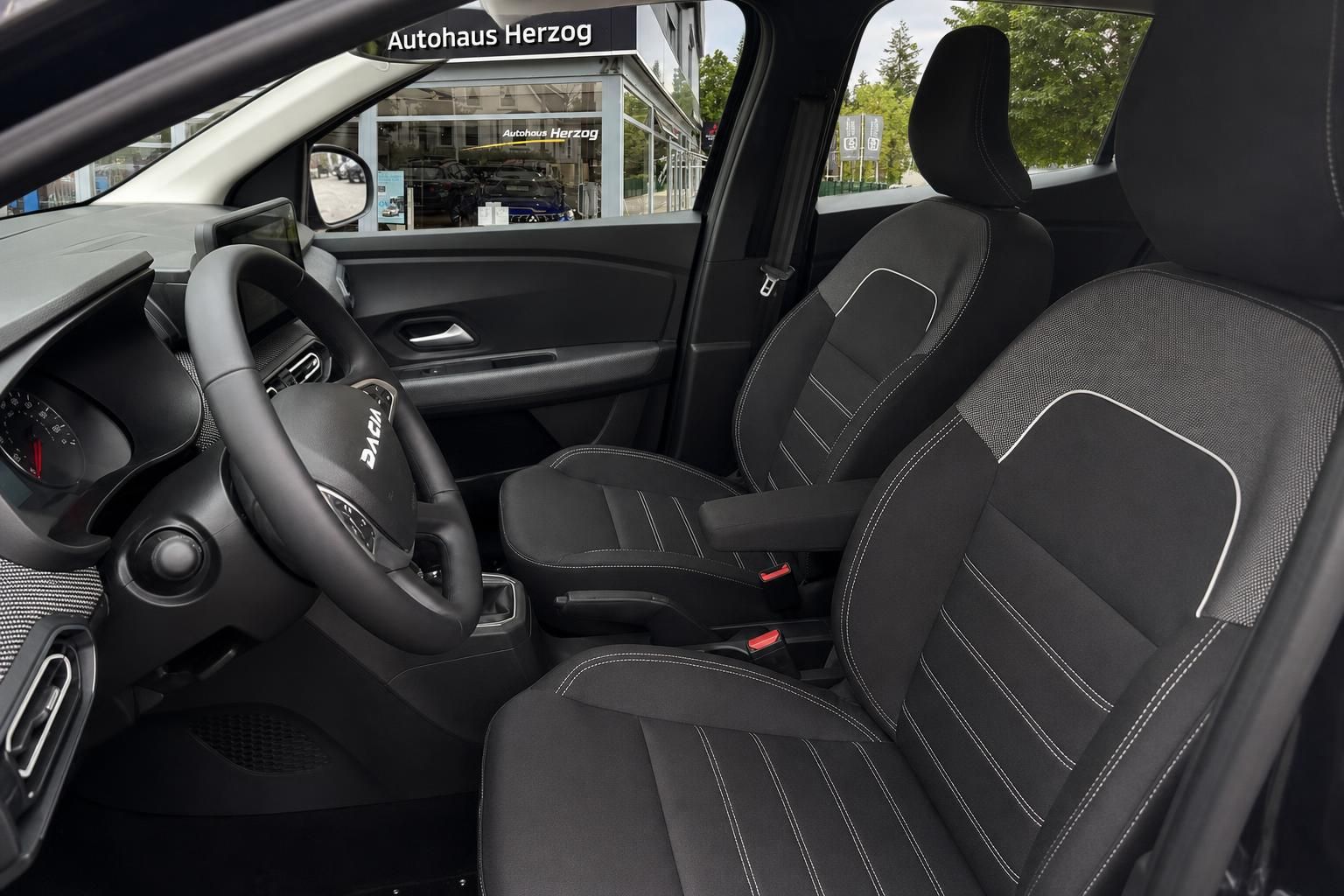 Dacia SUV Innenraum mit schwarzen Sitzen und Dacia Lenkrad