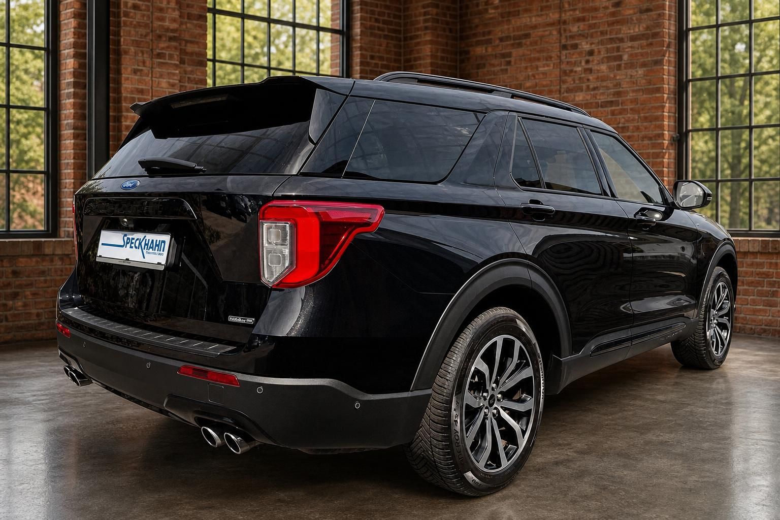 Ford Explorer schwarz Heckansicht seitlich in Halle mit Backsteinwand