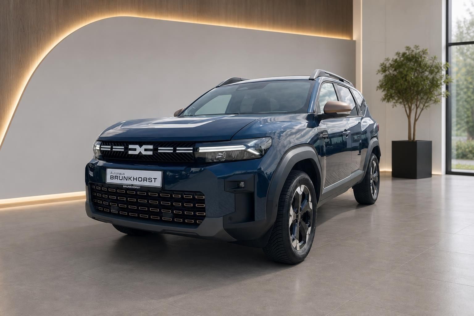 Dacia Bigster SUV in blau, Schrägansicht von vorn im modernen Autohaus-Showroom