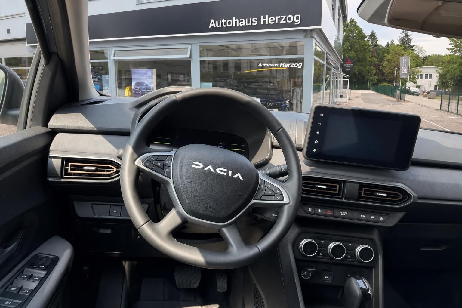 Dacia Fahrersitz Cockpit mit Lenkrad und Infotainment-Display