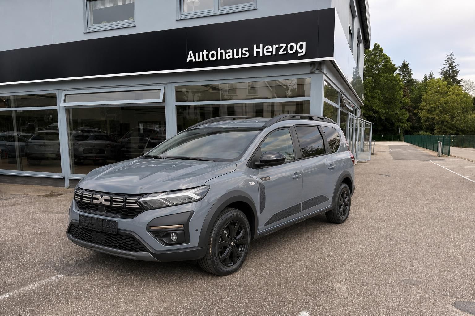Dacia Jogger grau vor Autohaus Herzog Seitenansicht