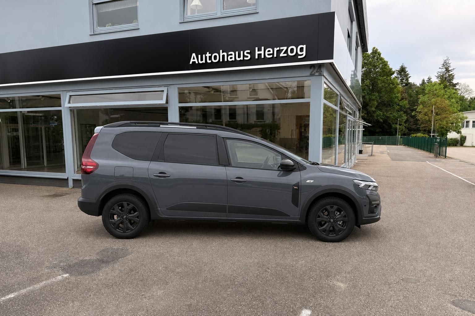 Dacia Jogger grau, Seitenansicht vor Autohaus Herzog geparkt