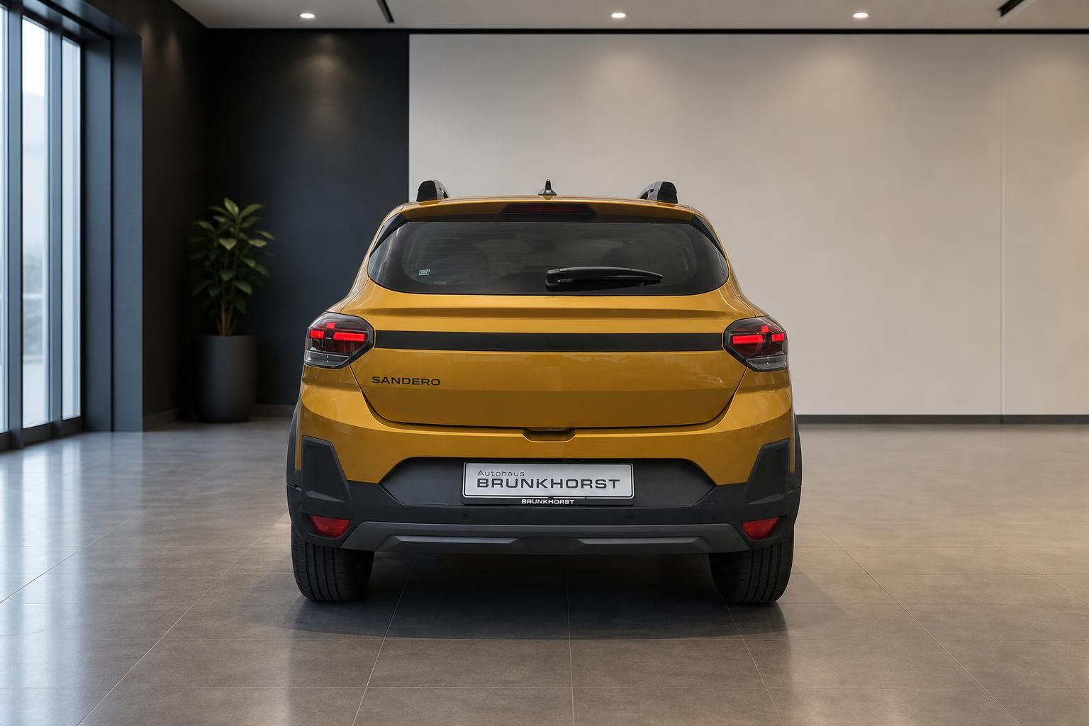 Dacia Sandero gelb, Heckansicht mit Ruecklichtern im Showroom