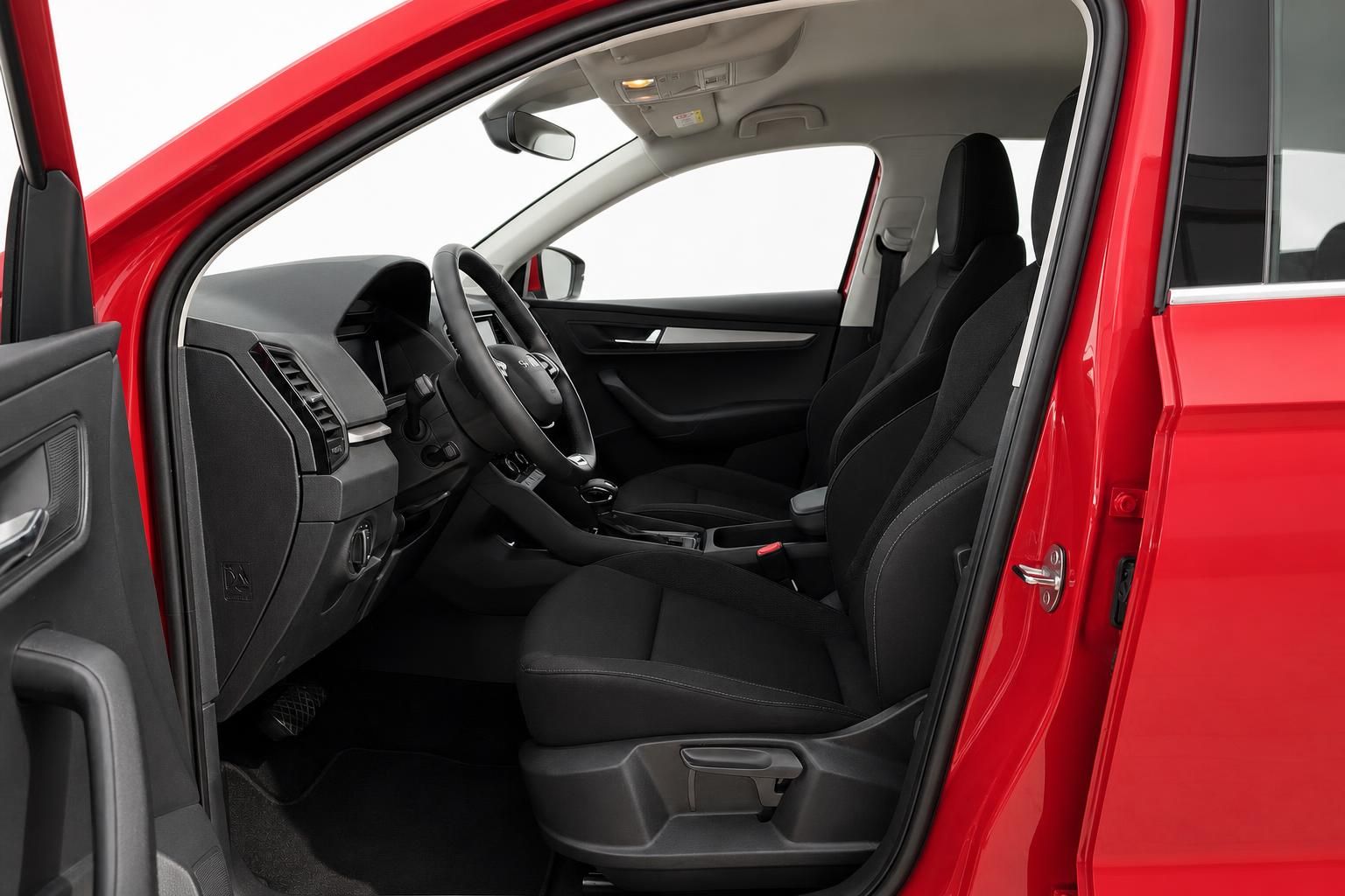 Fahrersitz und Cockpit eines roten Skoda durch geöffnete Tür