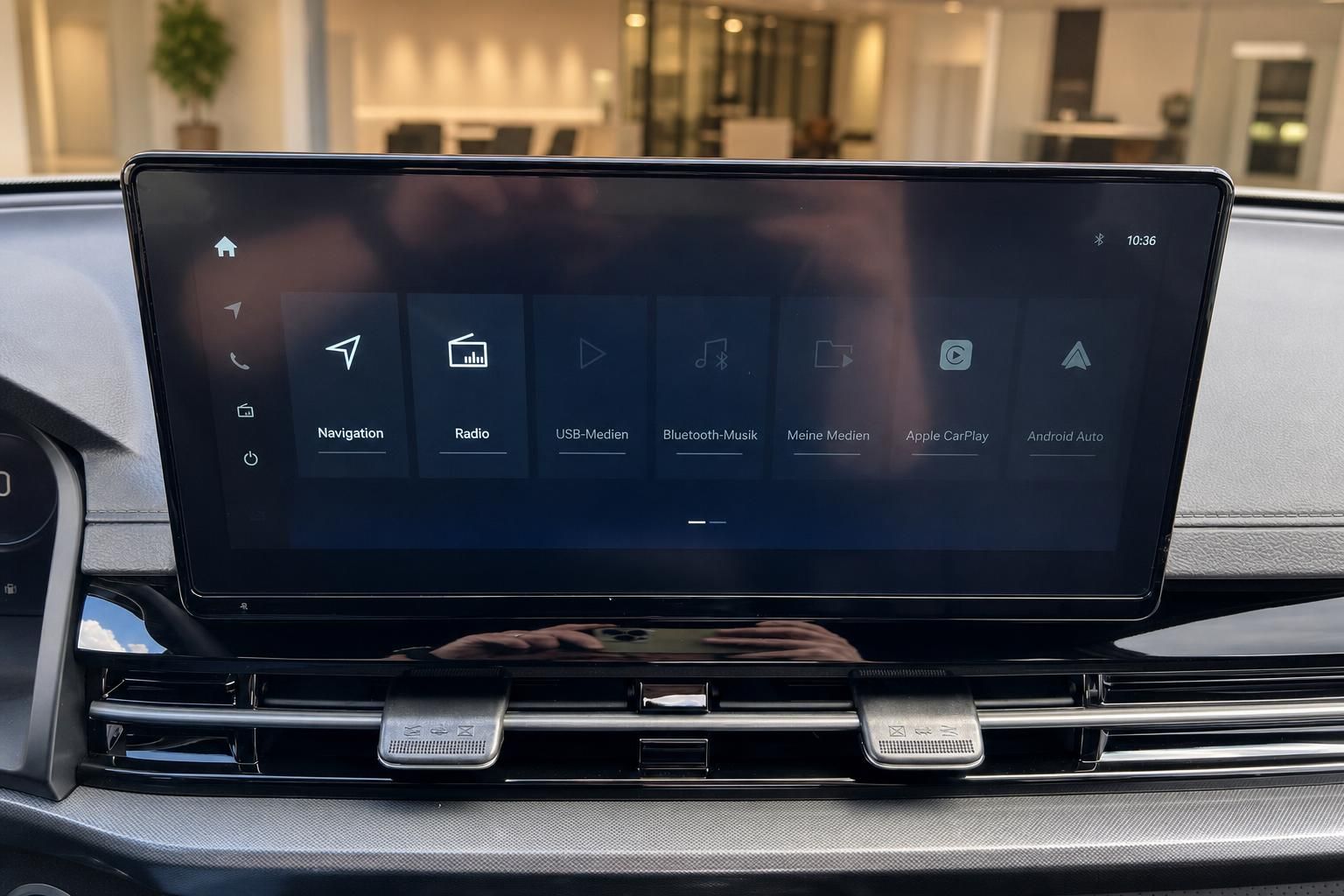 Infotainment-Touchscreen mit Navigationsmenu und Entertainment-Optionen im Fahrzeug-Dashboard