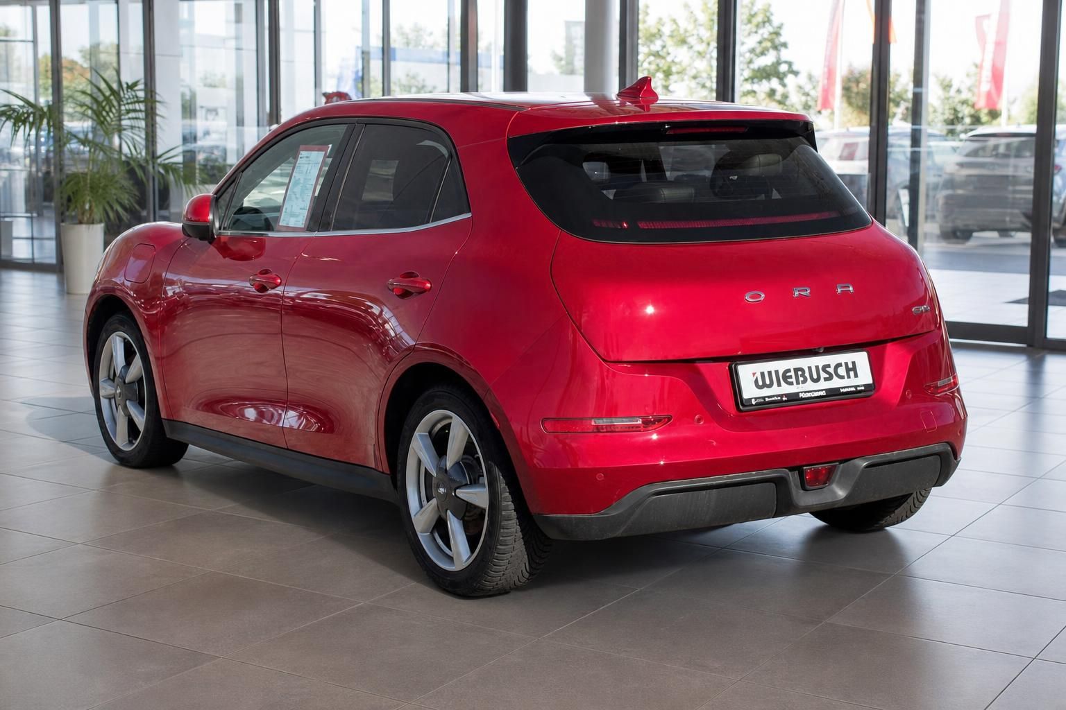 Roter Kleinwagen Heckansicht im Showroom - moderne Rückleuchten und Spoiler