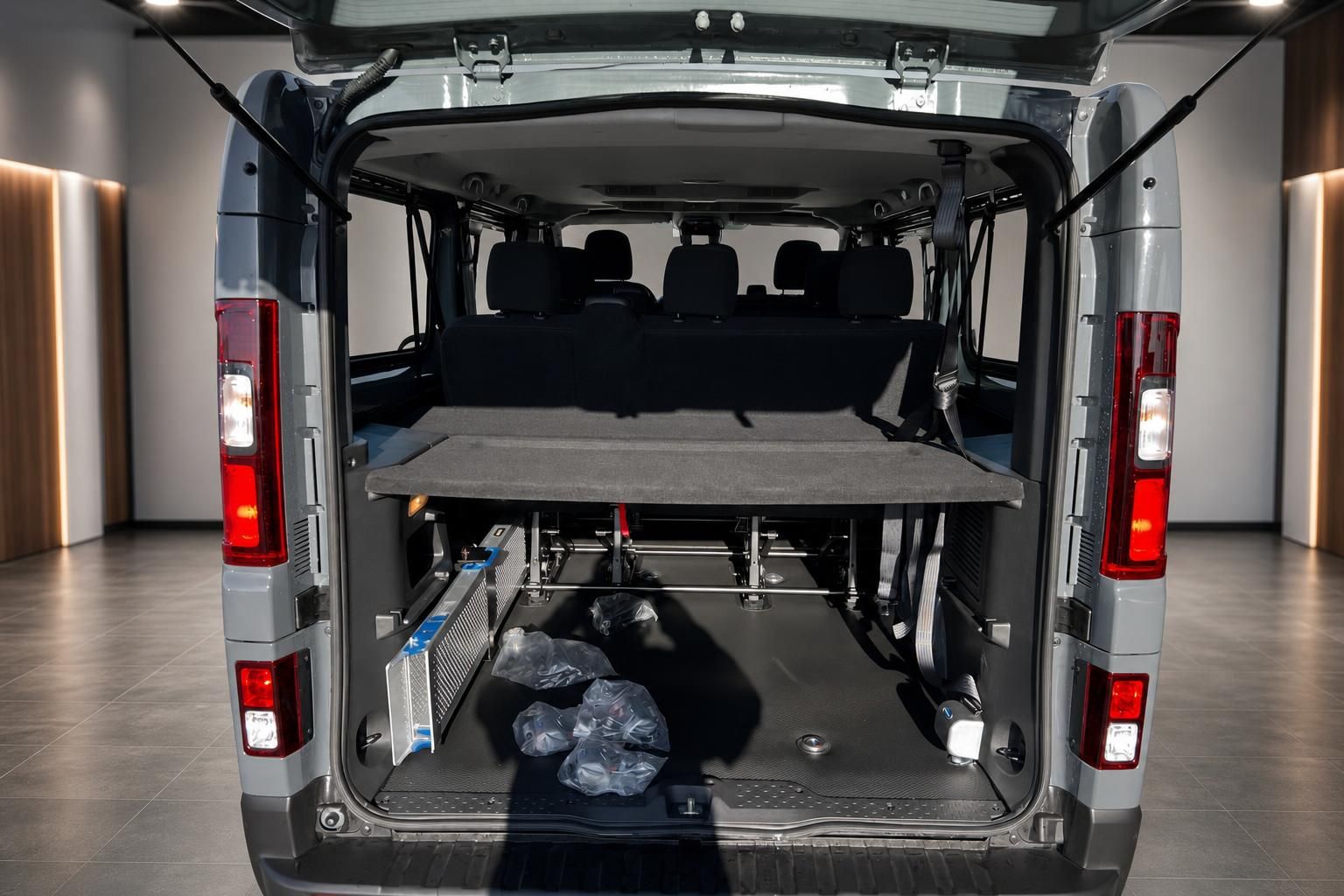 Transporter Laderaum mit ausklappbarer Liegefläche, geöffnete Heckklappe zeigt Innenausstattung