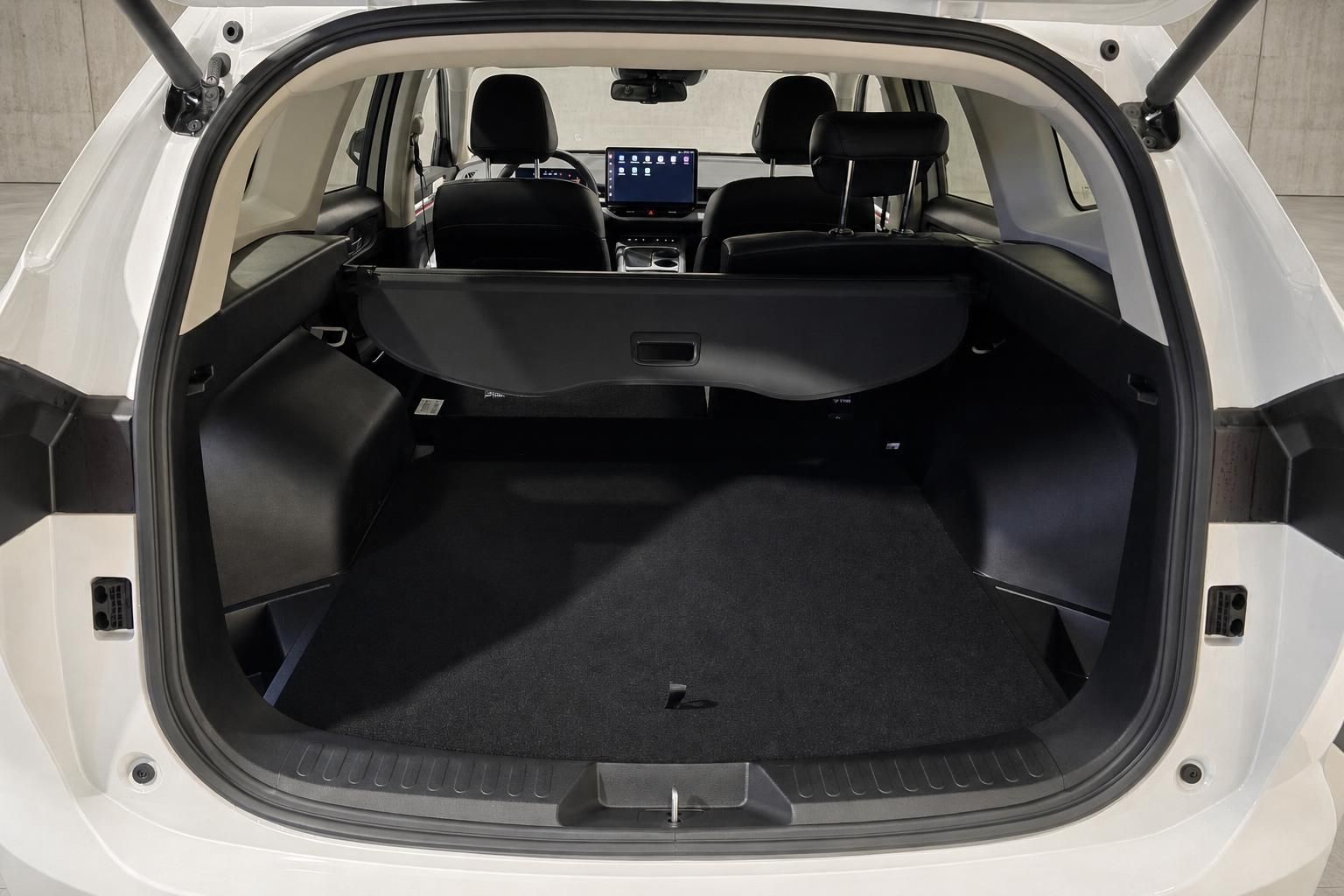 Kofferraum mit Ladeabdeckung im weißen SUV, Blick zu den Vordersitzen