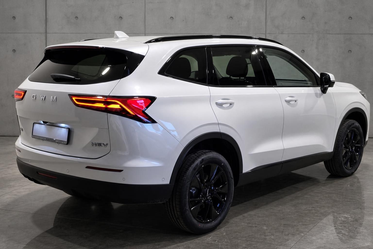 GWM Haval H6 HEV weiß, Seiten-Heckansicht mit schwarzen Alufelgen