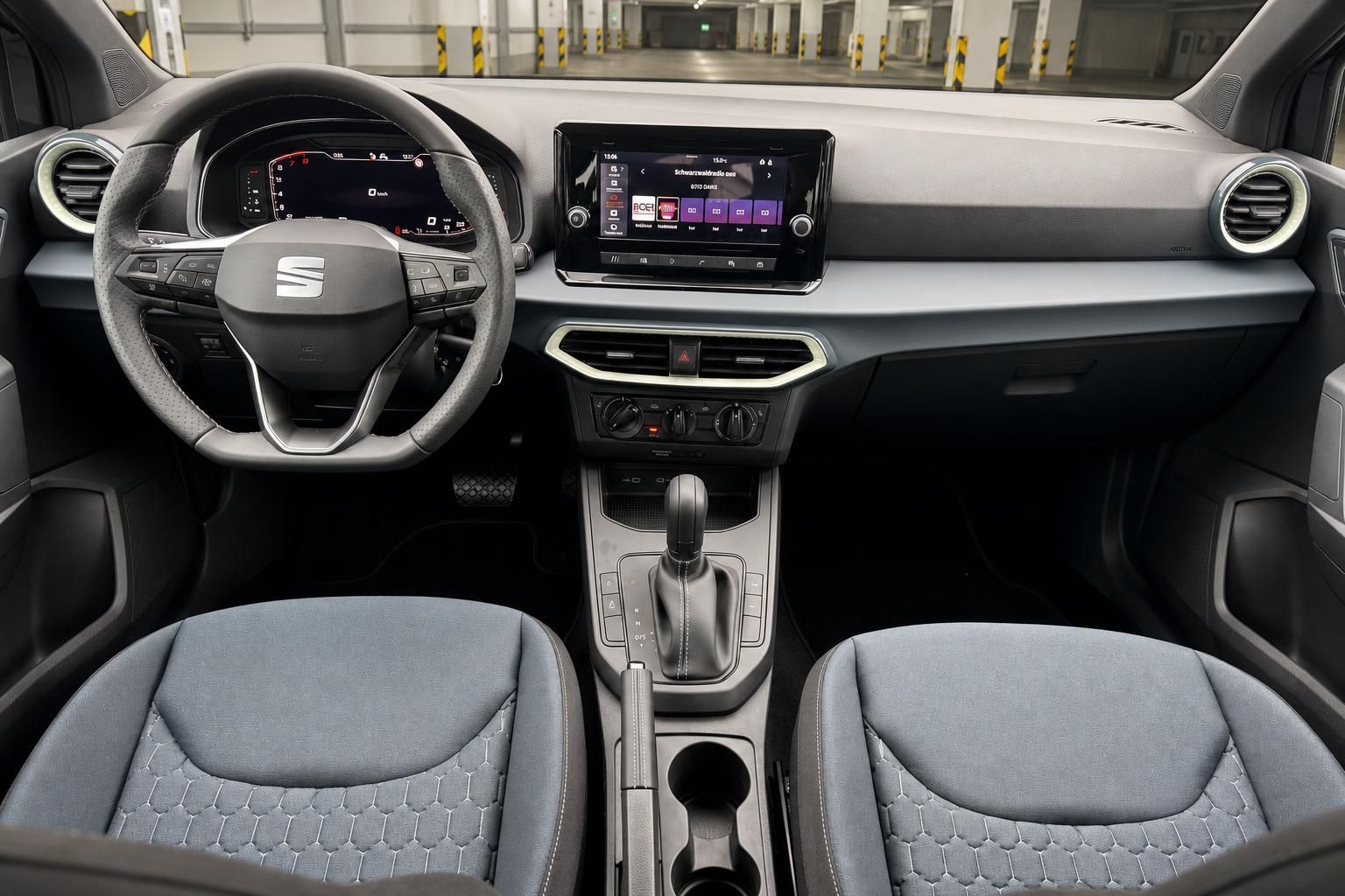 SEAT Cockpit mit Lenkrad, Automatikgetriebe, Touchscreen und blauen Stoffsitzen