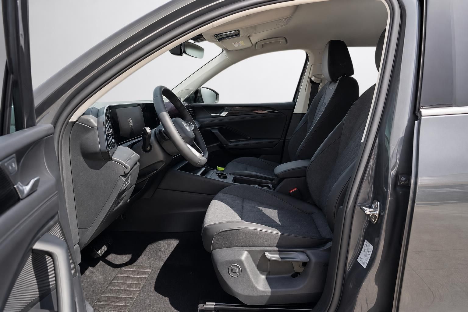 Fahrersitz und Cockpit des VW SUV durch geöffnete Tür
