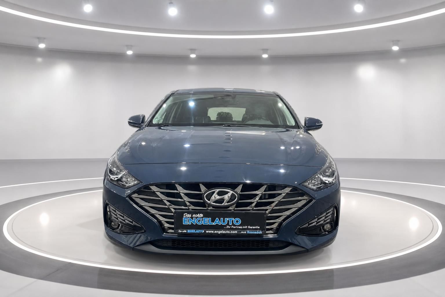 Hyundai i30 in grau-blau, Frontansicht mit Kühlergrill und Scheinwerfern im Studio