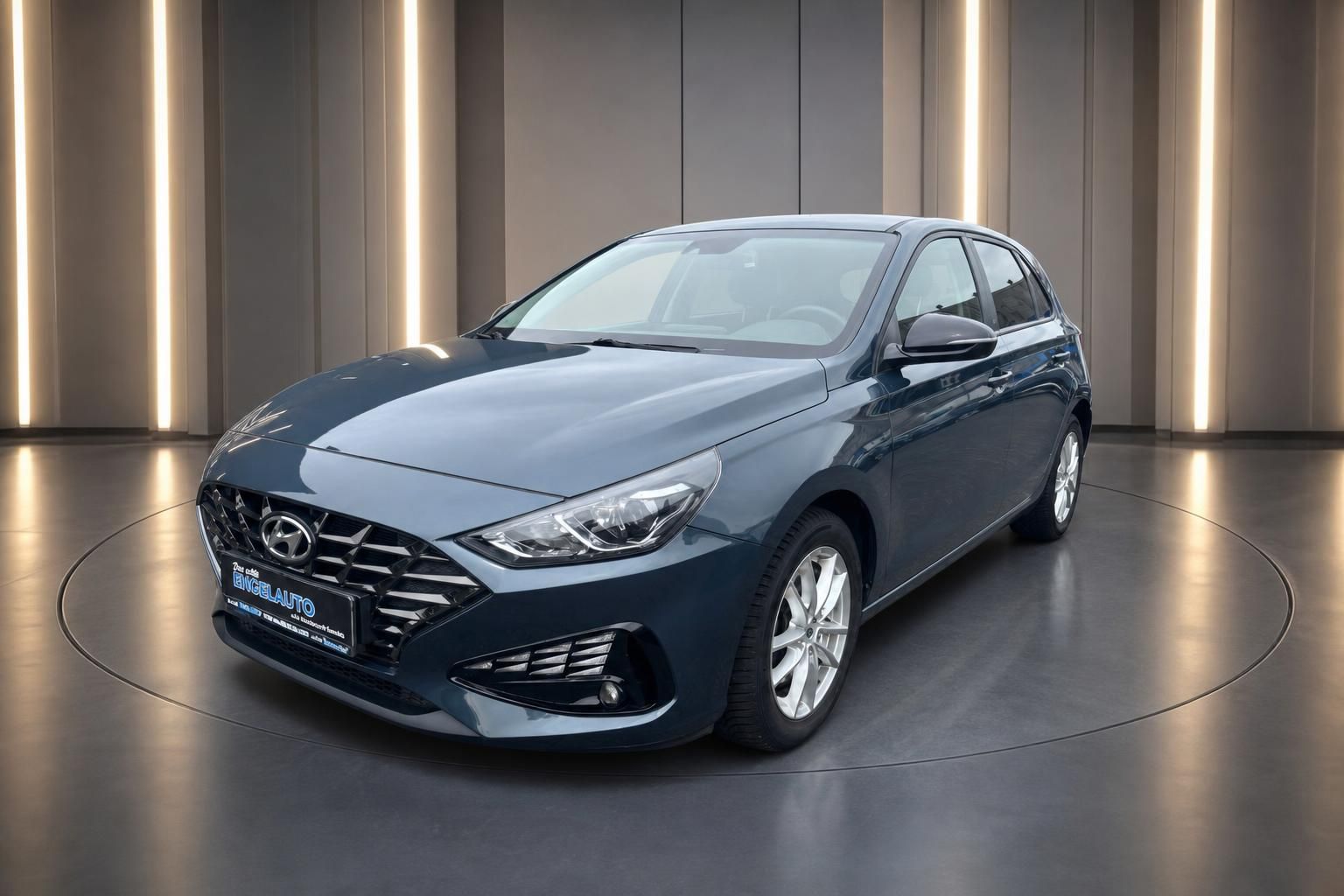 Hyundai i30 Kompaktklasse in grau-blau, Frontansicht in modernem Showroom