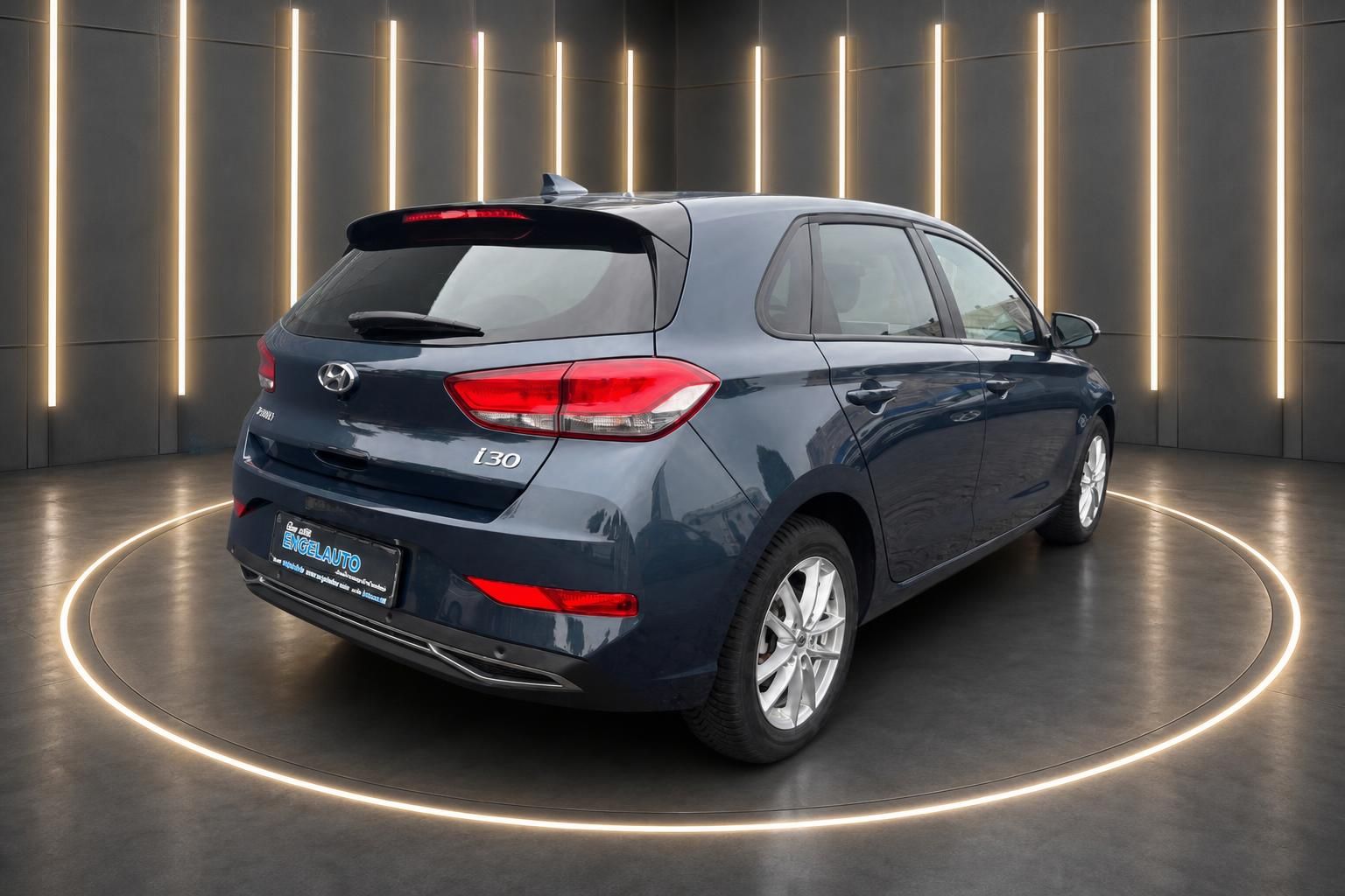 Hyundai i30 in grau, Heckansicht mit Spoiler und LED-Rückleuchten in modernem Showroom