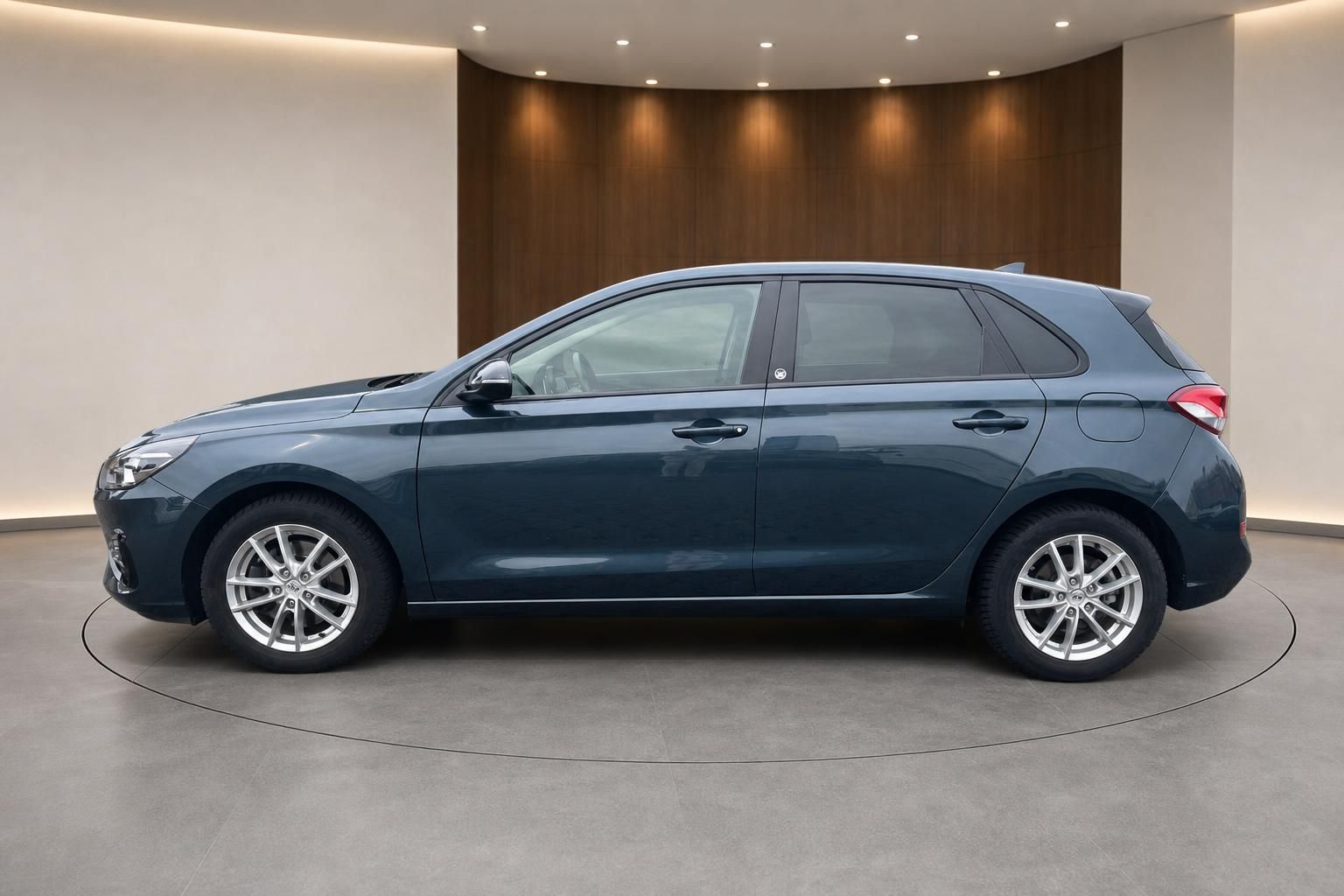 Hyundai i30 in grau, Seitenansicht mit Aluminiumfelgen in modernem Ausstellungsraum