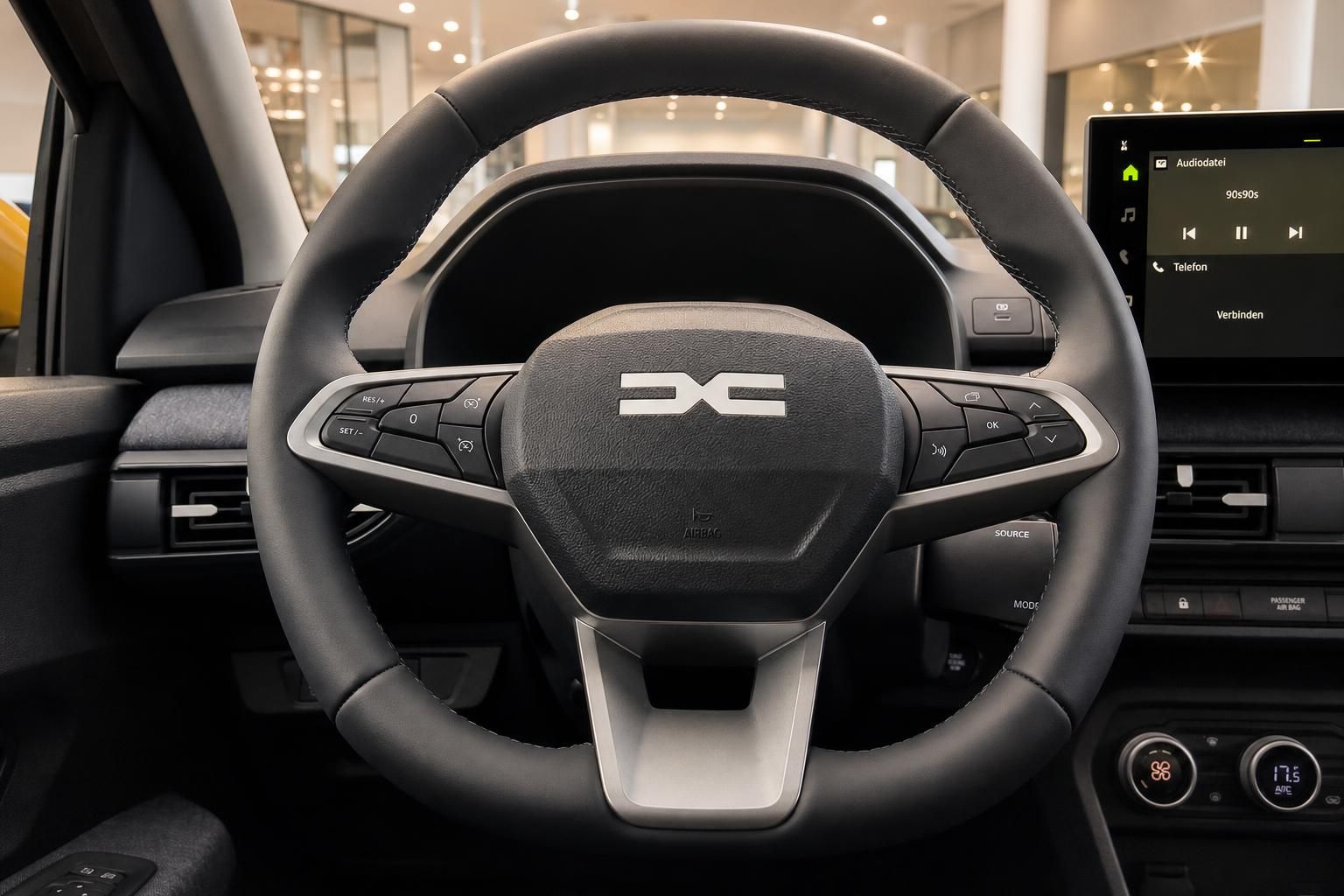 Lenkrad mit Multifunktionstasten und Infotainment-Display im Fahrzeuginnenraum