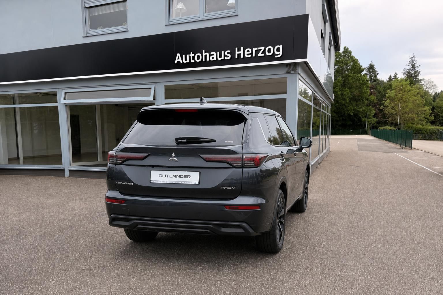 Mitsubishi Outlander PHEV Grau, Heckansicht vor Autohaus
