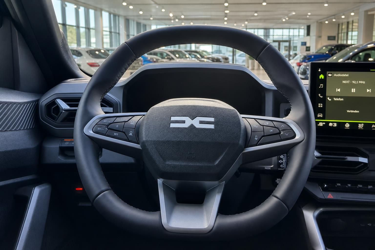 Fahrzeug Cockpit mit Lenkrad, Multifunktionstasten und Infotainment-Display im modernen Auto