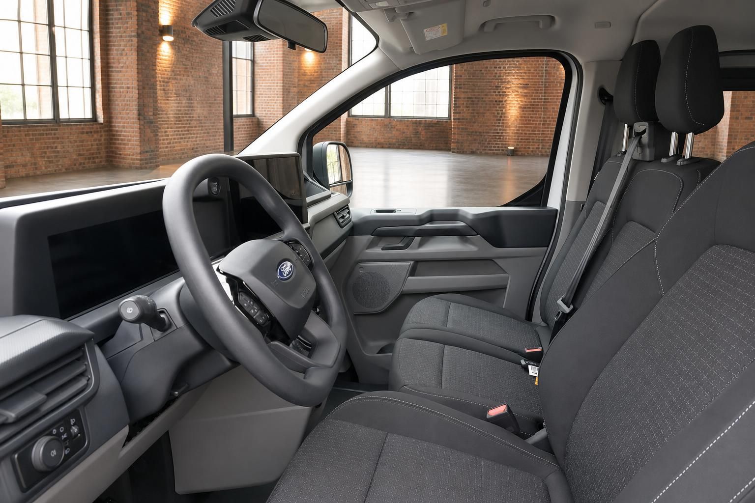 Ford Transit Innenraum – Fahrerseite mit Lenkrad, Armaturenbrett und Stoffsitzen in Grau