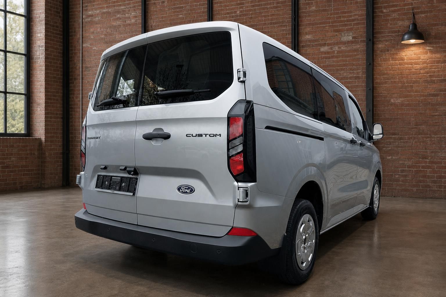 Ford Transit Custom silber Heckansicht schräg rechts in Industriehalle
