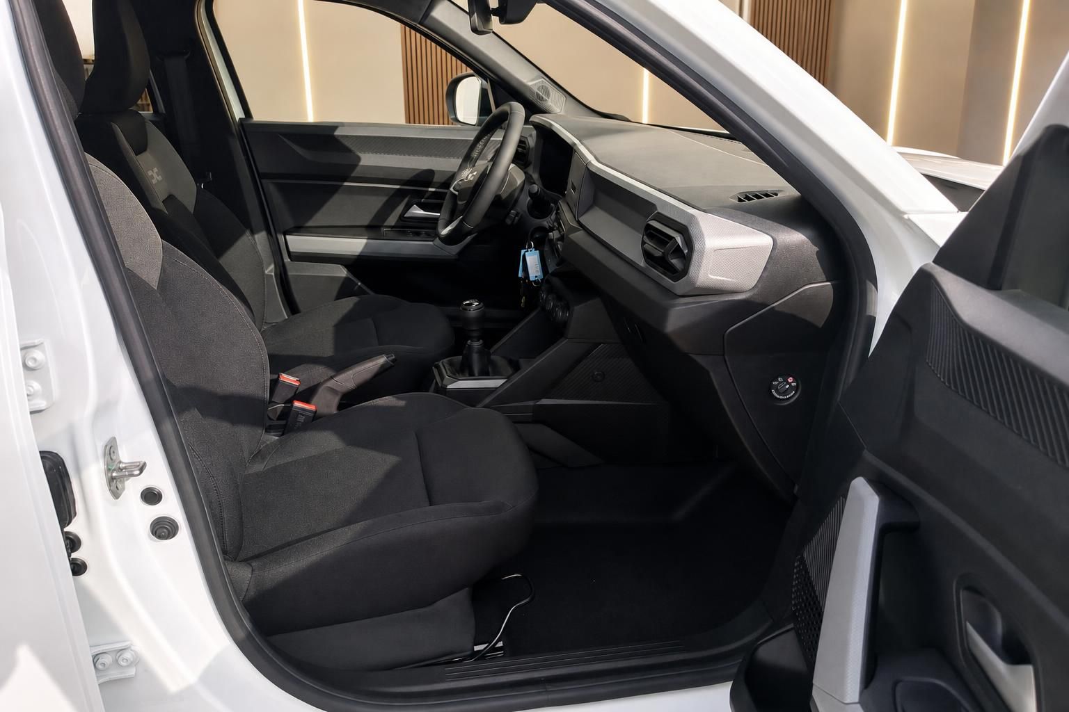 Auto Innenansicht Fahrerseite mit schwarzen Sitzen und offener Fahrertür