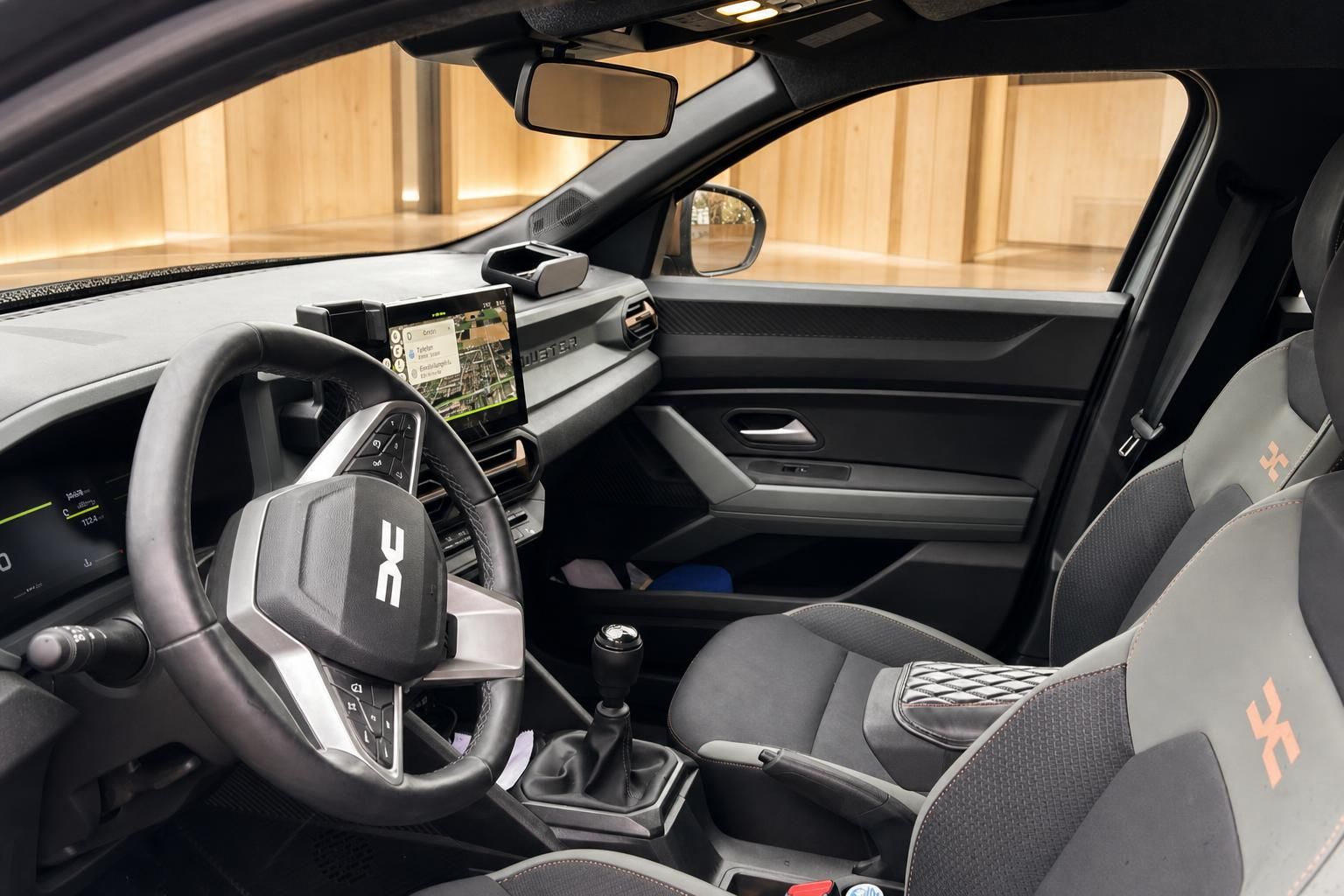Fahrzeuginnenraum mit Lenkrad, Mittelkonsole, Schaltgetriebe und digitalem Infotainment-Display