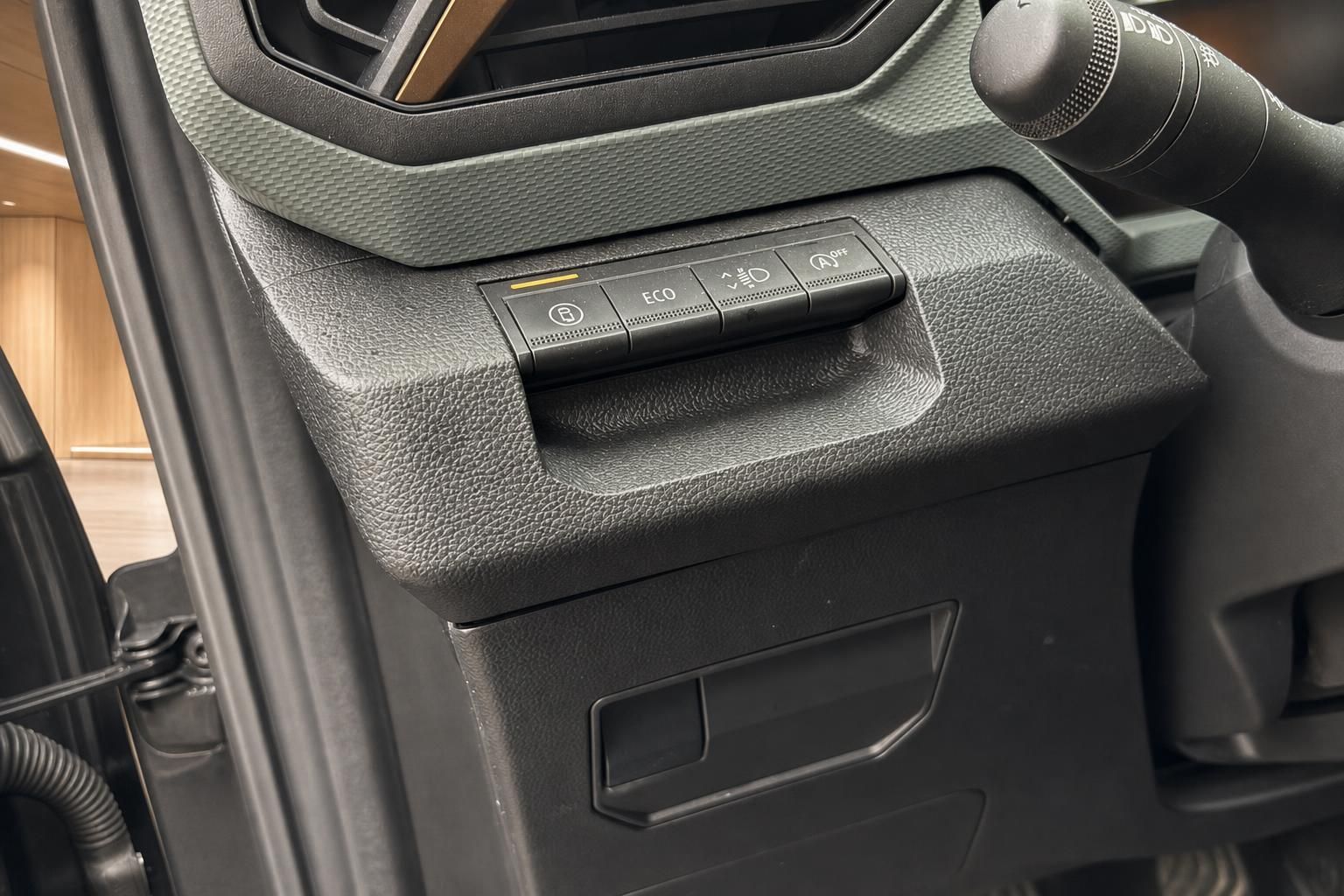 Fahrzeug-Innenraum Detailaufnahme Armaturenbrett mit ECO-Taste, Parkbremse und Fahrlichtschalter