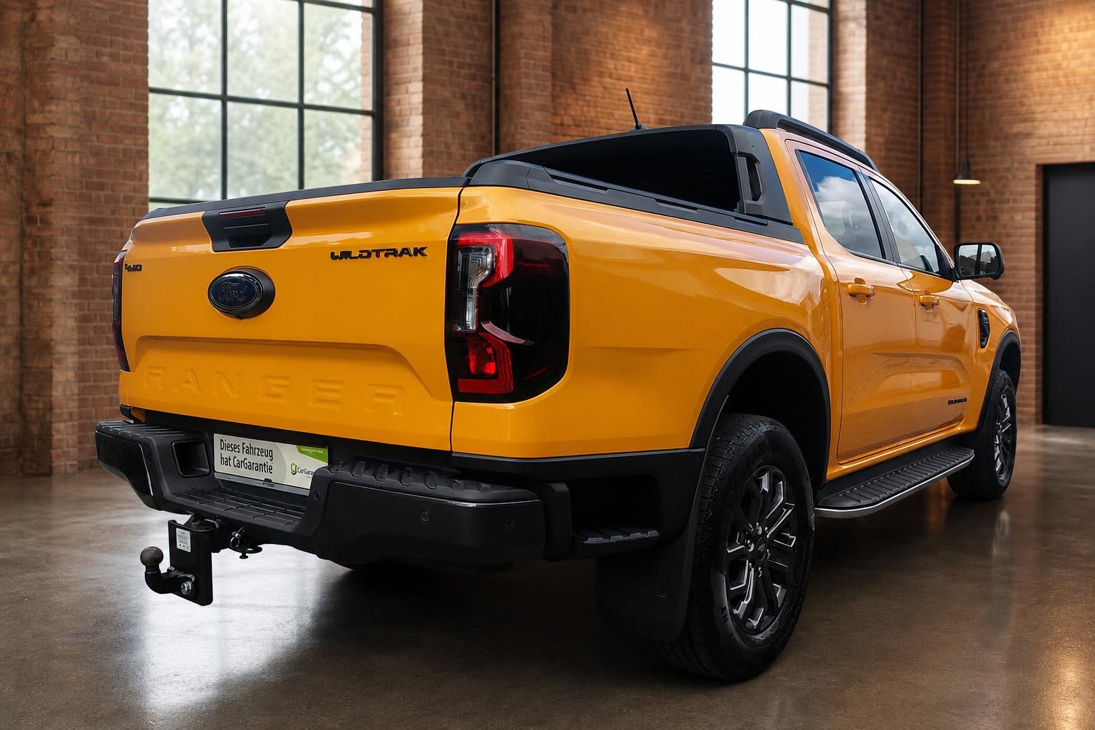 Ford Ranger Wildtrak 4x4 in Orange – Heckansicht schräg rechts mit Anhängerkupplung