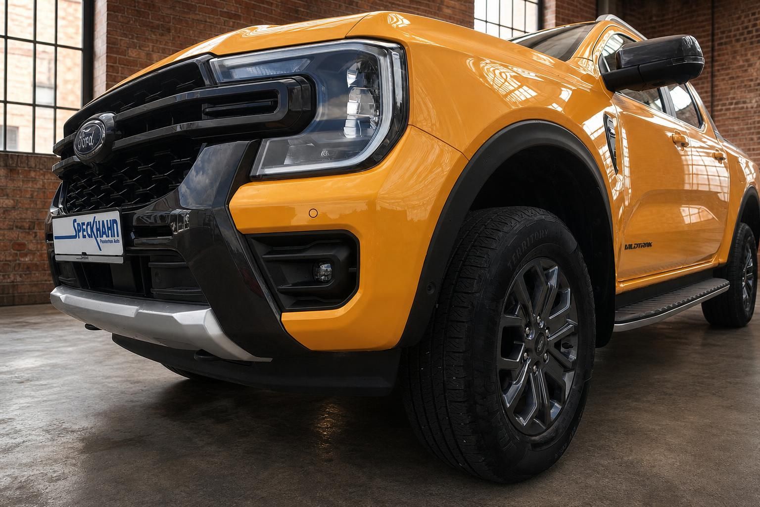 Ford Ranger Wildtrak in Orange – Frontpartie mit LED-Scheinwerfern und Felge in Nahaufnahme
