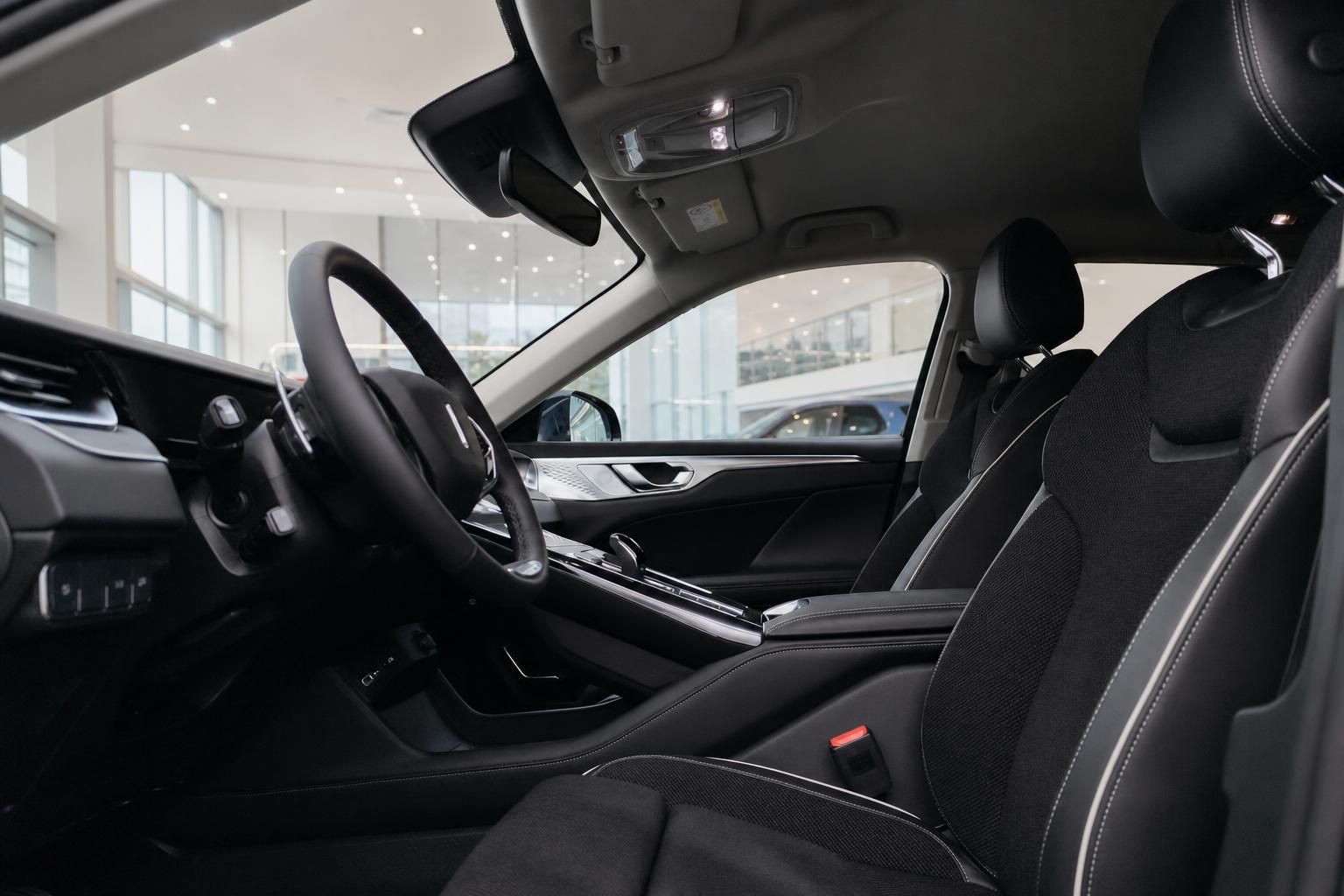 Fahrzeuginnenraum mit schwarzen Stoffsitzen, Lenkrad und Mittelkonsole im Autohaus