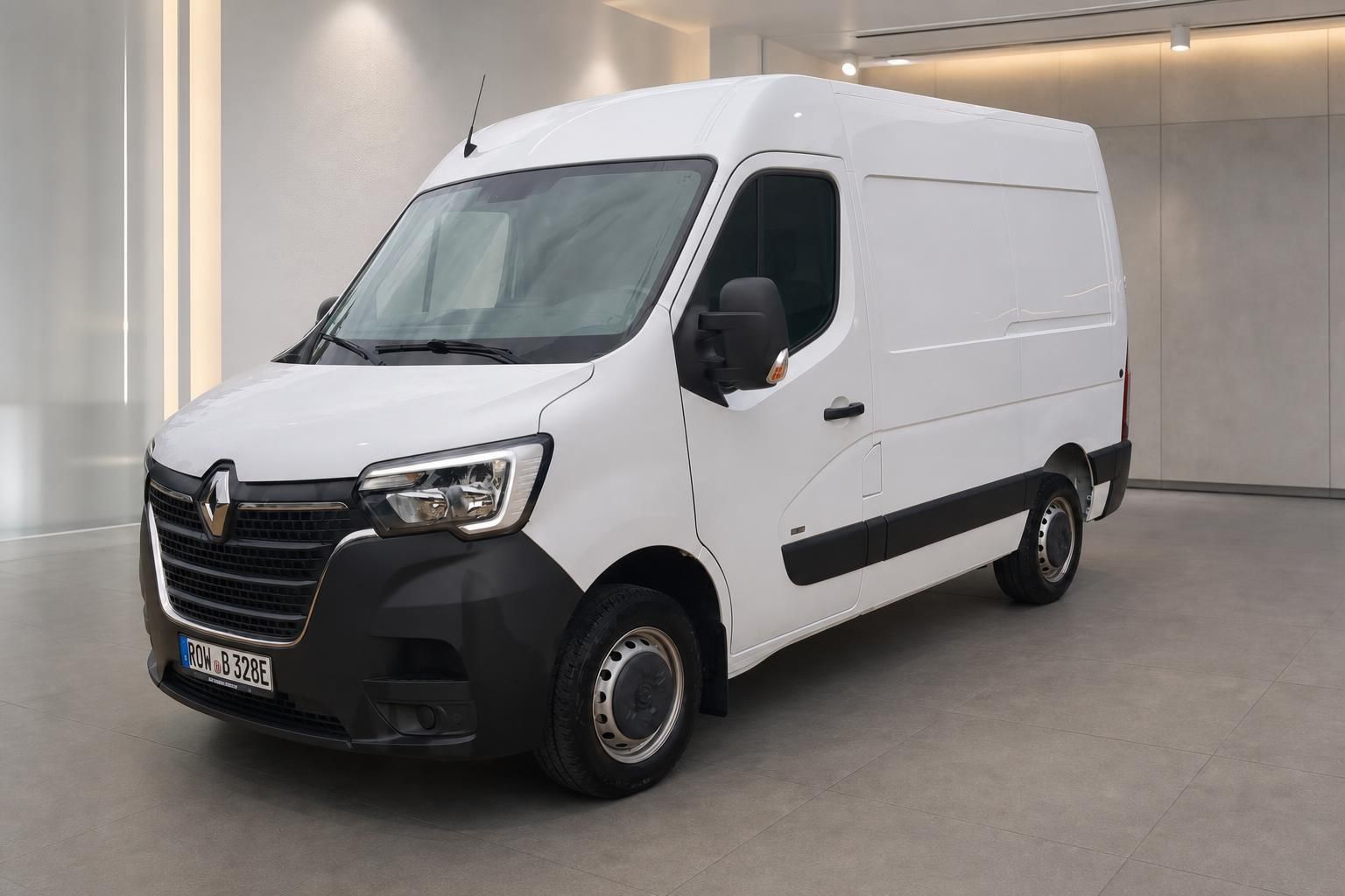 Weißer Renault Transporter in Showroom - Frontansicht mit schwarzen Stoßfängerelementen