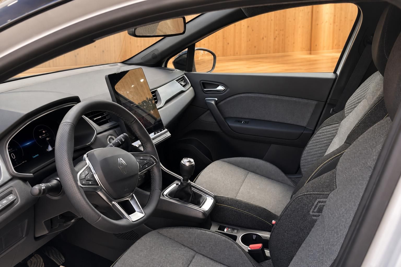 Renault Innenraum mit Fahrersitz, Lenkrad, Schaltknauf und zentralem Touchscreen
